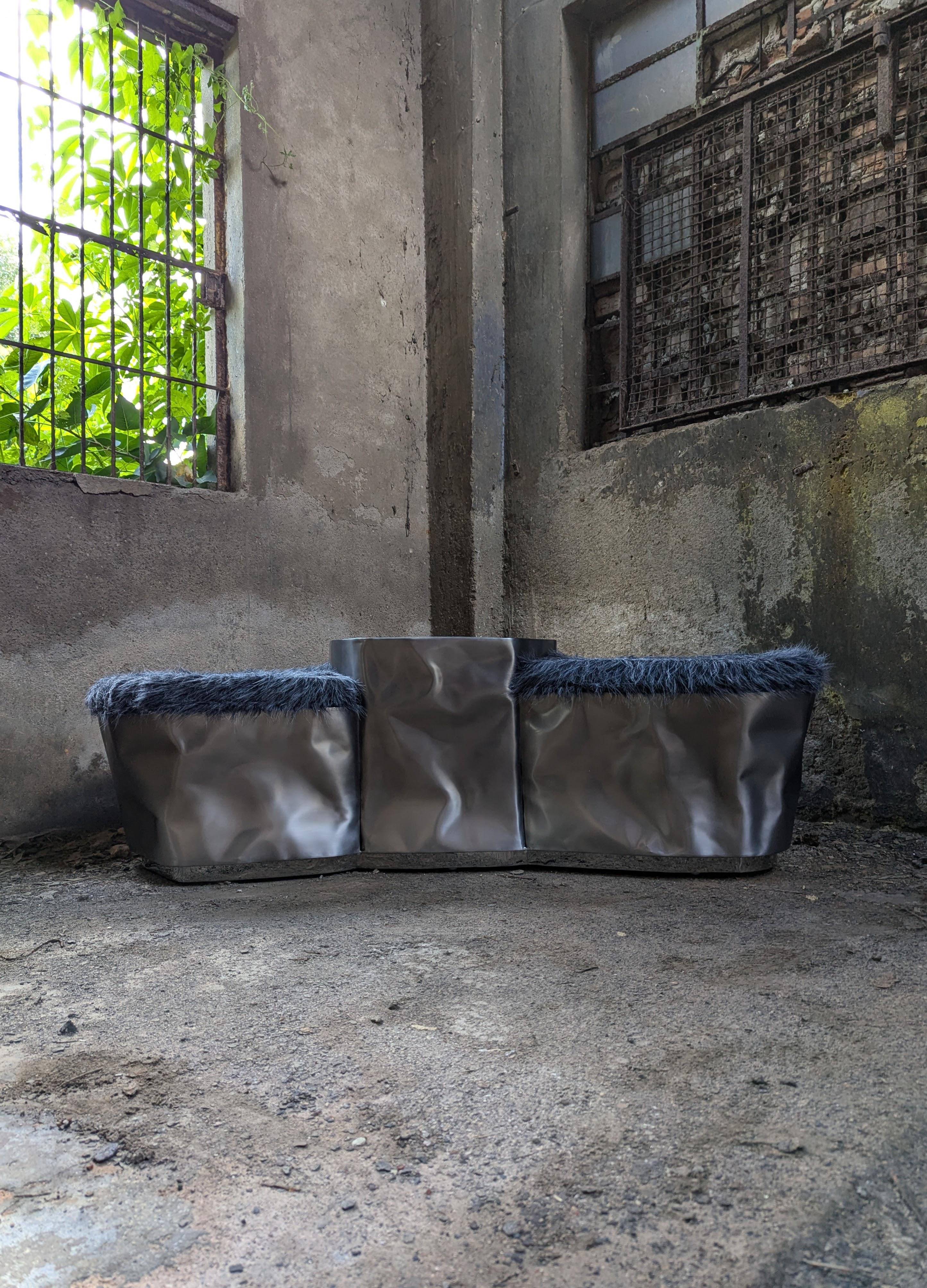 Banc Triolith de NITUSH AROOSH
Dimensions : D 50 x L 165 x H 38 cm. 
MATERIAL : Acier inoxydable et fausse fourrure.

Disponible en différentes finitions. Toutes nos lampes peuvent être câblées en fonction de chaque pays. Si elle est vendue aux