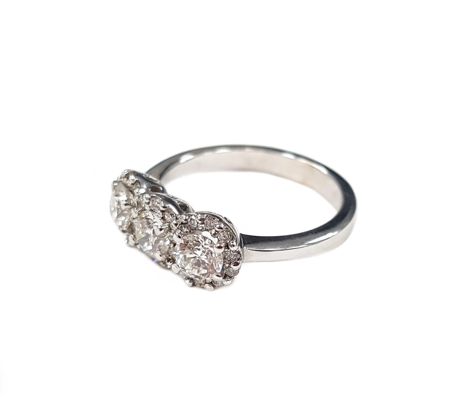 Sparkling perfection, instant heirloom: this ring's three stunning central round-cut white diamonds, each has a single halo of smaller white diamonds surrounding it (1.13 carats total). 

The photographed ring is a 12.5 EU/6.5 US ring size but it