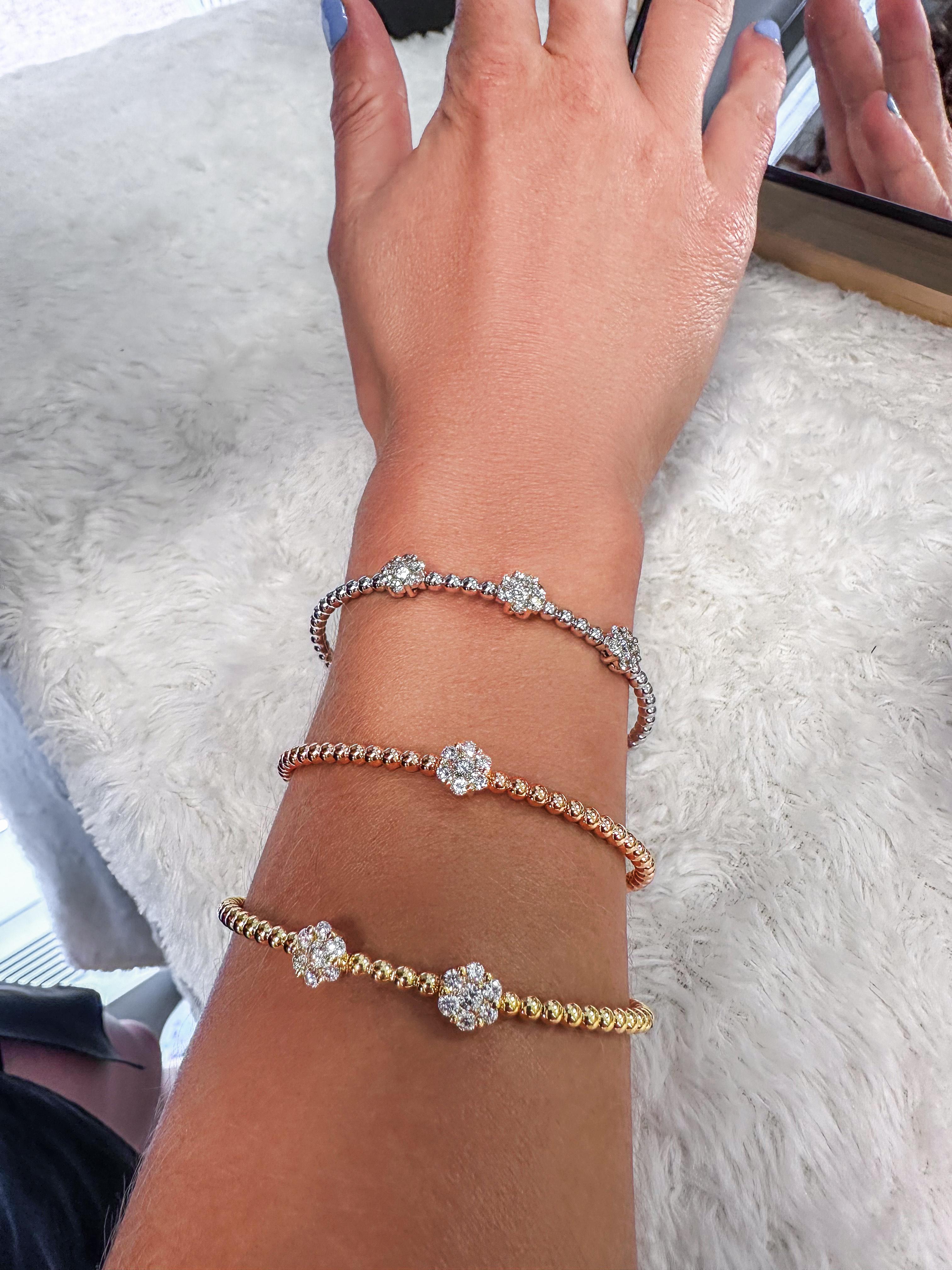 This elegant 1.20 carat triple diamond cluster bangle bracelet showcases three radiant floral-inspired clusters set on a sleek, high-polish 18K yellow gold band. The balanced spacing of each cluster offers a refined sparkle across the wrist, making