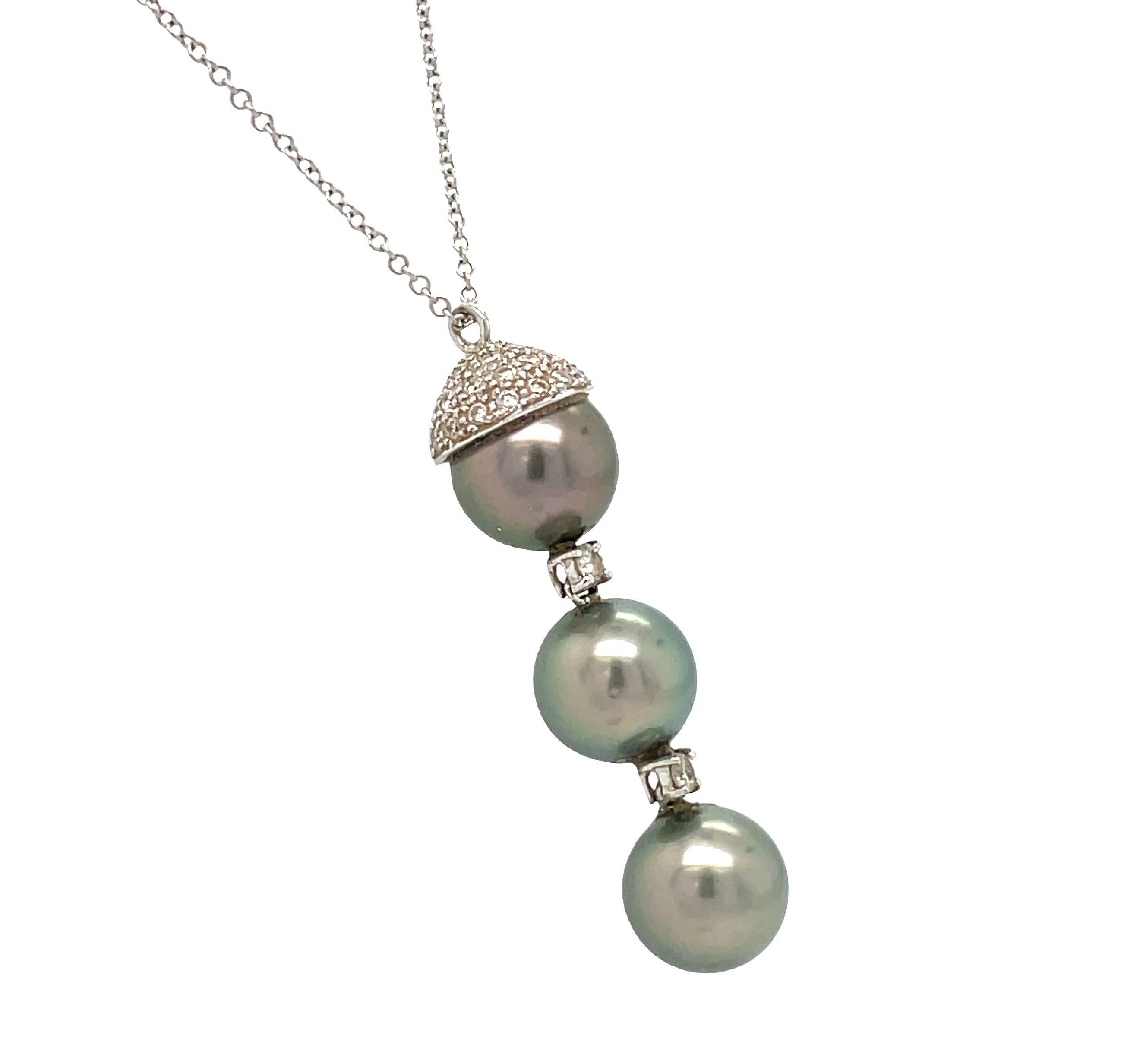 This exquisite 14K white gold necklace, adorned with black cultured Akoya pearls and diamonds, showcases a wonderful dangle style, with round brilliant cut diamonds elegantly suspended alongside beautiful freely dangling pearls.

The pendant