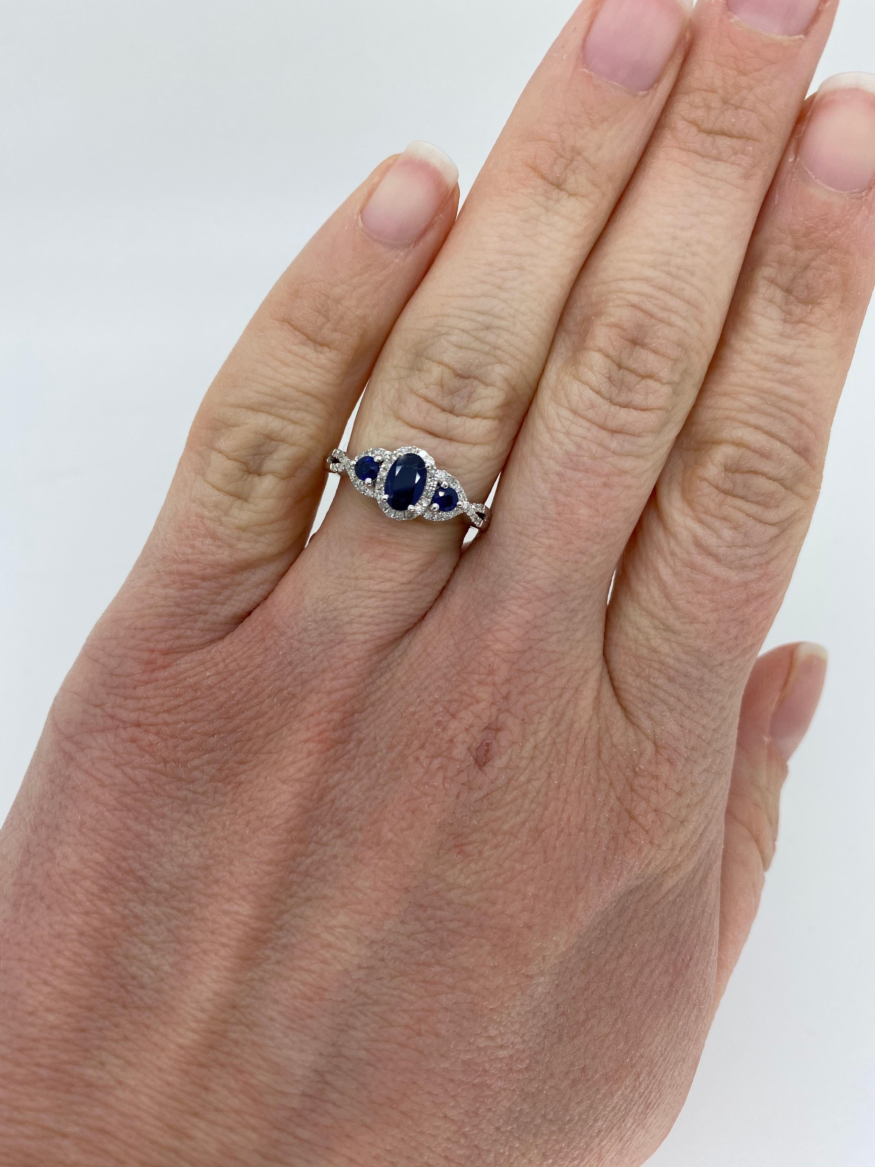 Triple halo sapphire and diamond ring crafted in 10k white gold. 

Gemstone: Sapphire & Diamonds
Gemstone Carat Weight: One Approximately 5.96x4.17mm Sapphire, Two Approximately 2.60mm Sapphires
Diamond Carat Weight: Approximately .20CTW 
Diamond