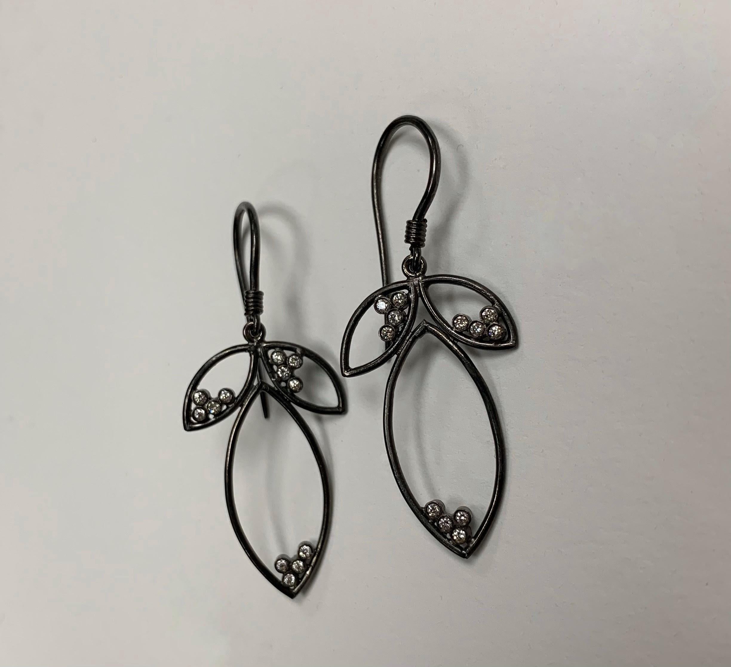 The 18 karat Blackened Gold dangle earrings feature 0.24 carats of White Diamonds. The diamonds are bezel set and appear to be dew drops on the leaves. The 3 leaves are connected at the top and the earrings finish on the ear on french wire.

A2 by