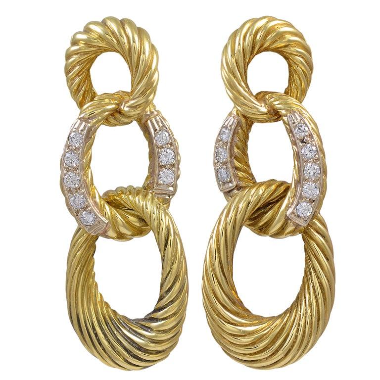 Dramatic important triple hoop drop earring 18k gold; center loop set with full cut diamonds. 1.30cts of diamondsA strong smart look