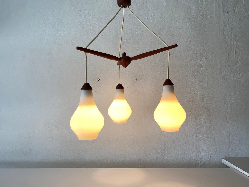 Triple opal glass & teak ceiling lamp by Uno & Östen Kristiansson for Luxus Vittsjö, 1960s Sweden

Scandinavian Modern chandelier.

The lamp is in very good vintage condition. 

This lamp works with E14 light bulb.
Wired and suitable to use
