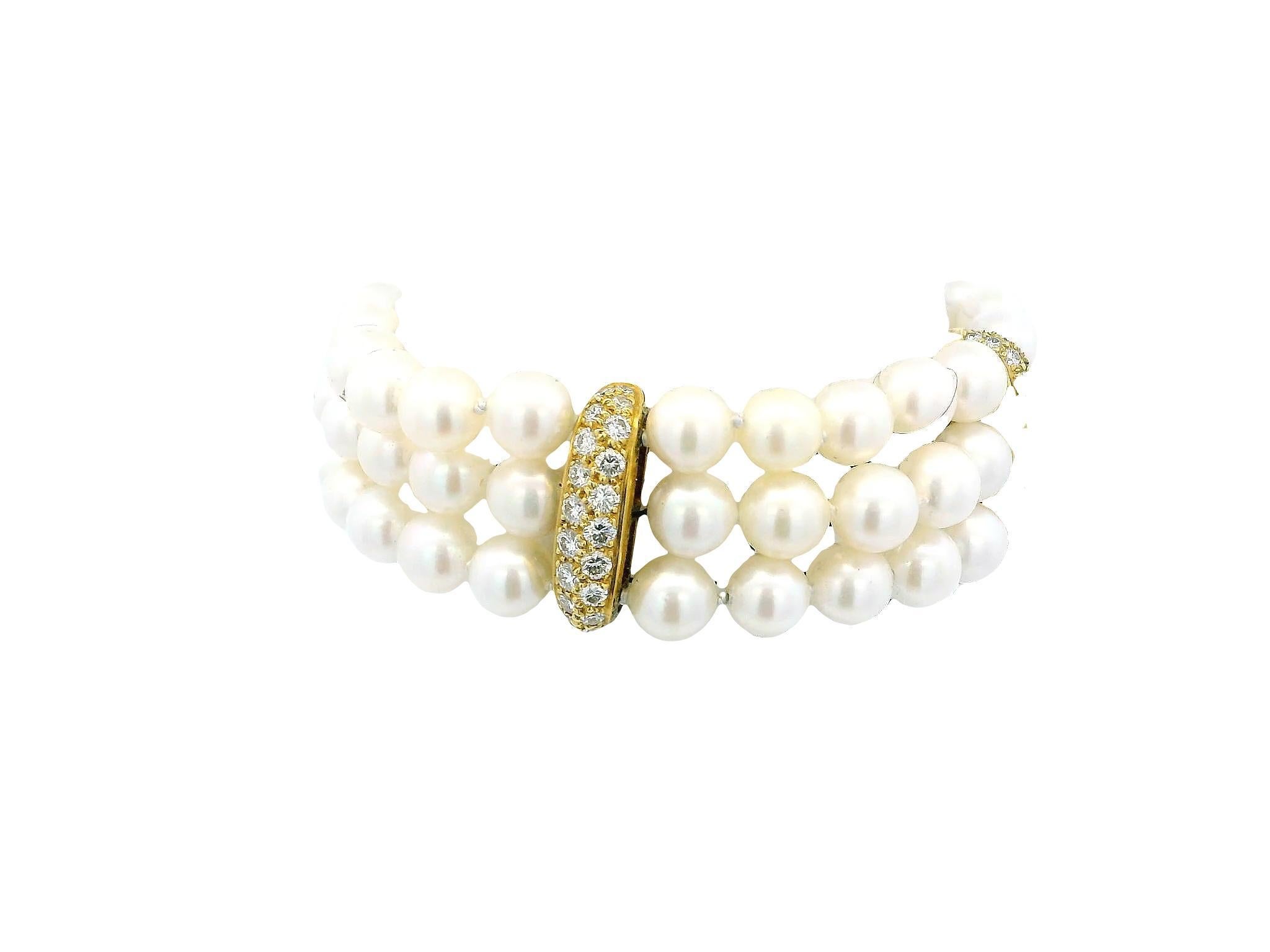 Esta impresionante pulsera del siglo XXI está fabricada en oro de 18 quilates. Presenta tres filas de lustrosas perlas, cada una de ellas meticulosamente dispuesta para crear un diseño armonioso y lujoso. Las perlas están intercaladas con detalles