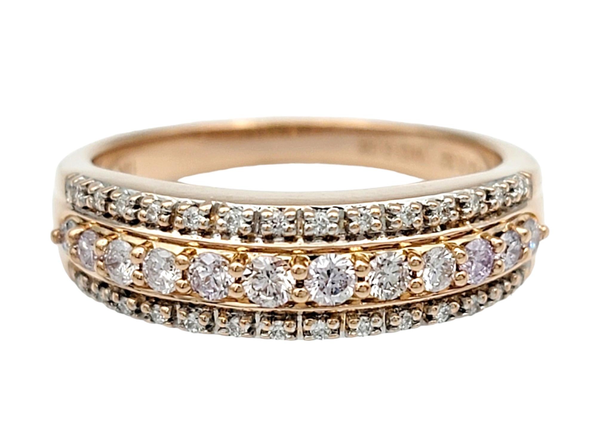 Ring Size: 7

This exquisite three-row diamond band ring is a true symbol of elegance and sophistication. Crafted in 18 karat rose gold, it features a captivating design with three rows of dazzling diamonds. The center row is adorned with larger