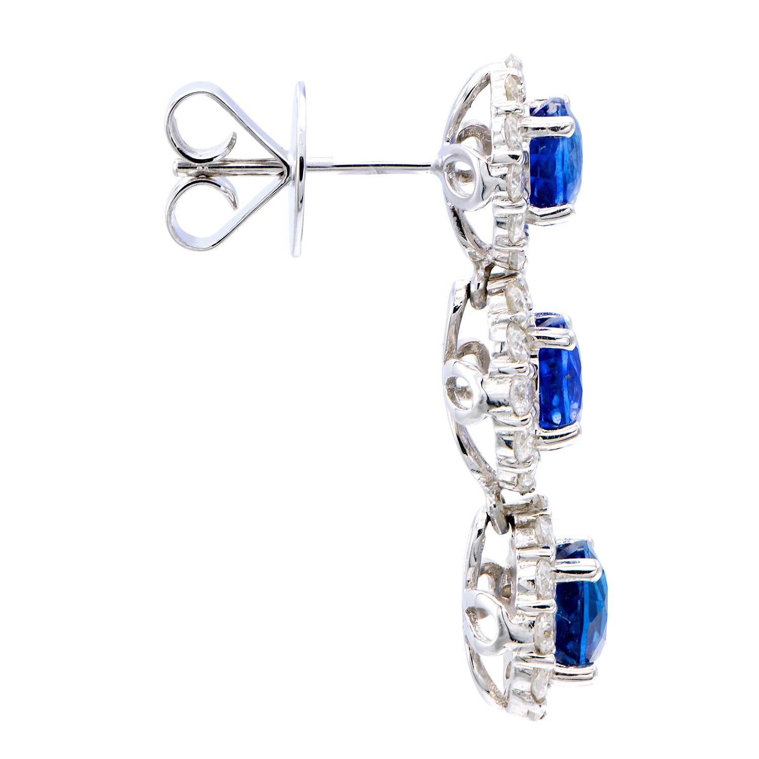 These stunning earrings are made of 6 royal blue sapphires totalling 4.46 carats which are surrounded by 72 round VS2, G color diamonds totaling 1.75 carats of shine. They are set in 5.2 grams of 18 karat white gold and have a post with a push back