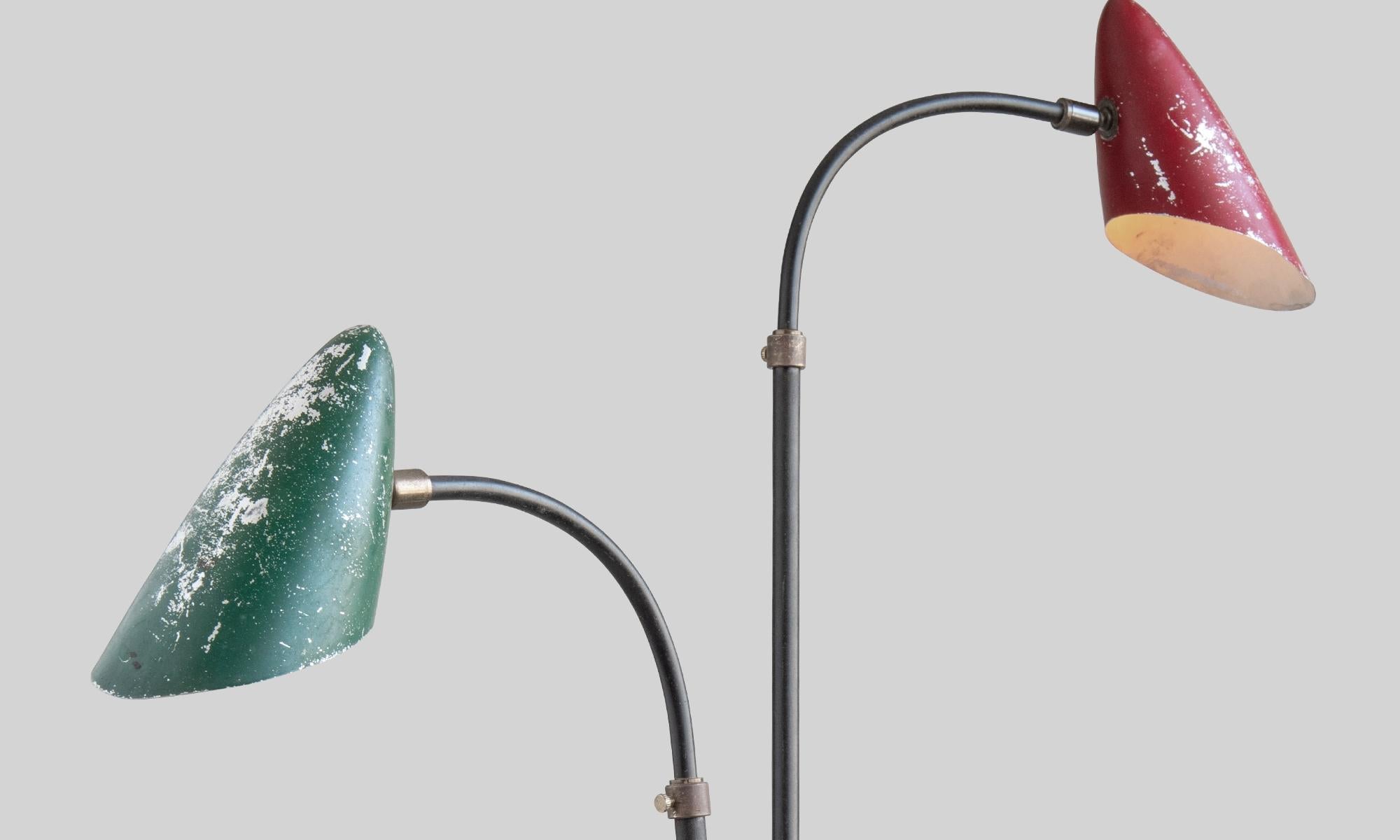 Curvy metal floor lamp with brass details, articulating arms, and painted metal shades.
France, circa 1960.