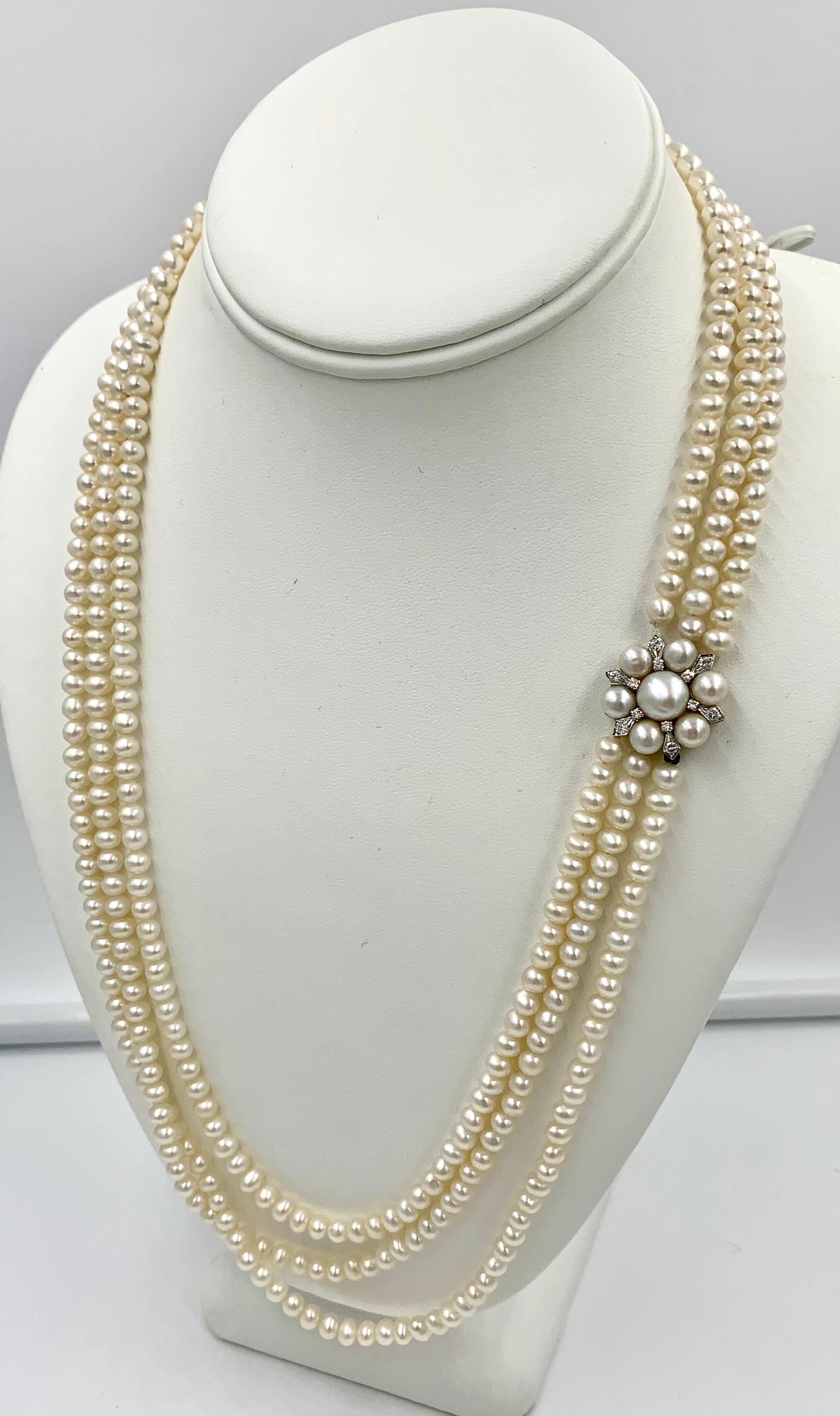 A gorgeous antique Triple Strand Pearl and Diamond Necklace in 14 Karat White Gold.  The Retro Hollywood Regency jewel is a stunner.  It has three rows of 5 mm luscious Pearls.  The Pearls are stunning with beautiful nacre and lustre.  The clasp is