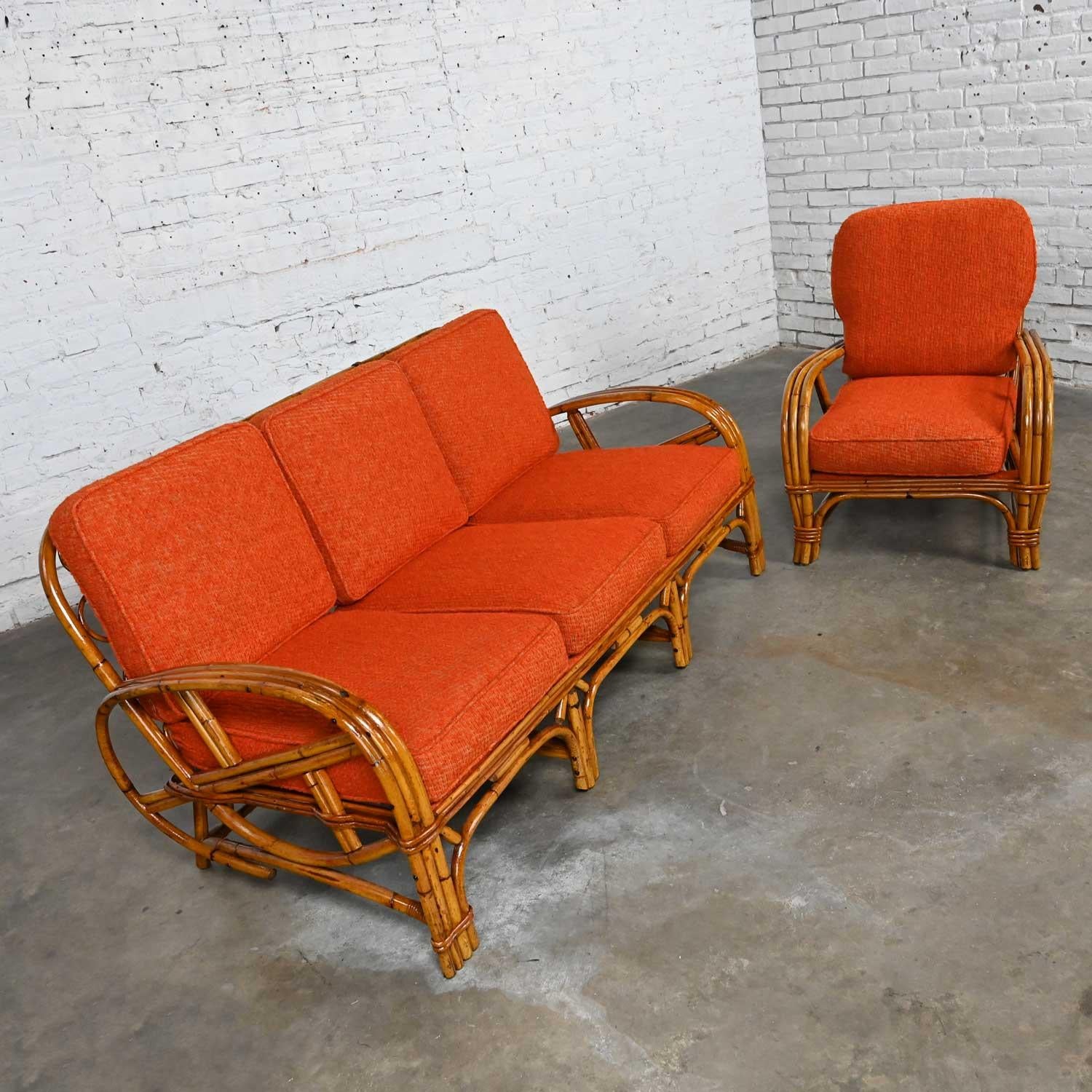 Wonderful vintage triple strand rattan sofa and chair in the style of Heywood Wakefield with zippered orange nubby fabric and original foam filled cushions. Beautiful condition, keeping in mind that these are vintage and not new so will have signs