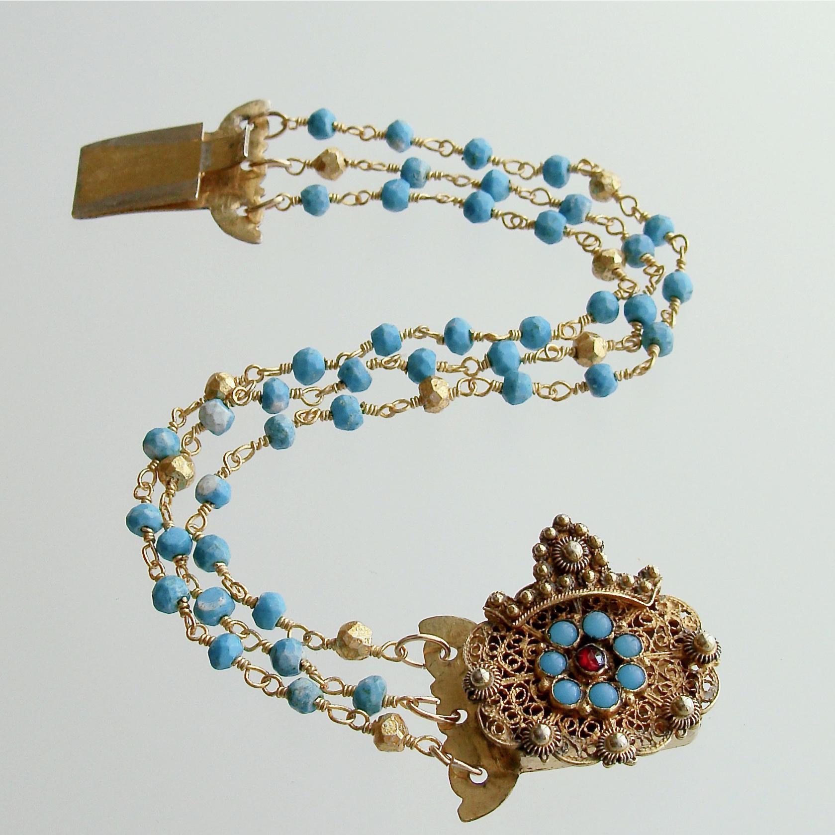 Seona Bracelet.
Triple strands of turquoise have been intercepted with gilded pyrite to create this charming and delicate bracelet.  The antique Georgian clasp had been adorned with a flower of turquoise and garnets while addressing the lovely