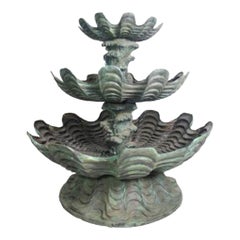 Fuente de bronce con forma de concha y olas en cascada de tres niveles