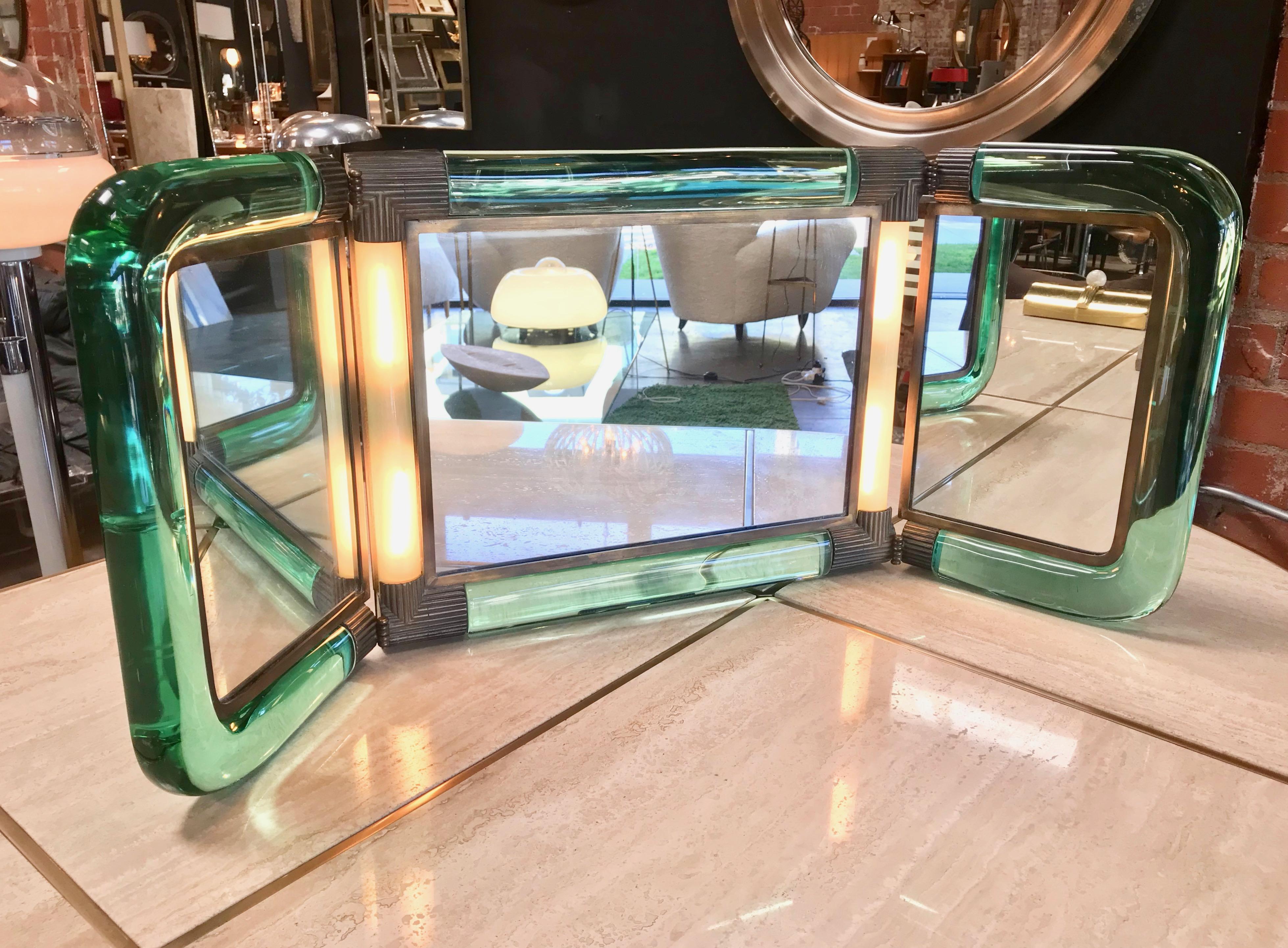 Triple vanity table light mirror, 1940s.
A very beautiful and rare piece with nice brass details. In very good condition with charming patina.
Width closed: 22in.
Width opened: 30 in.
 
