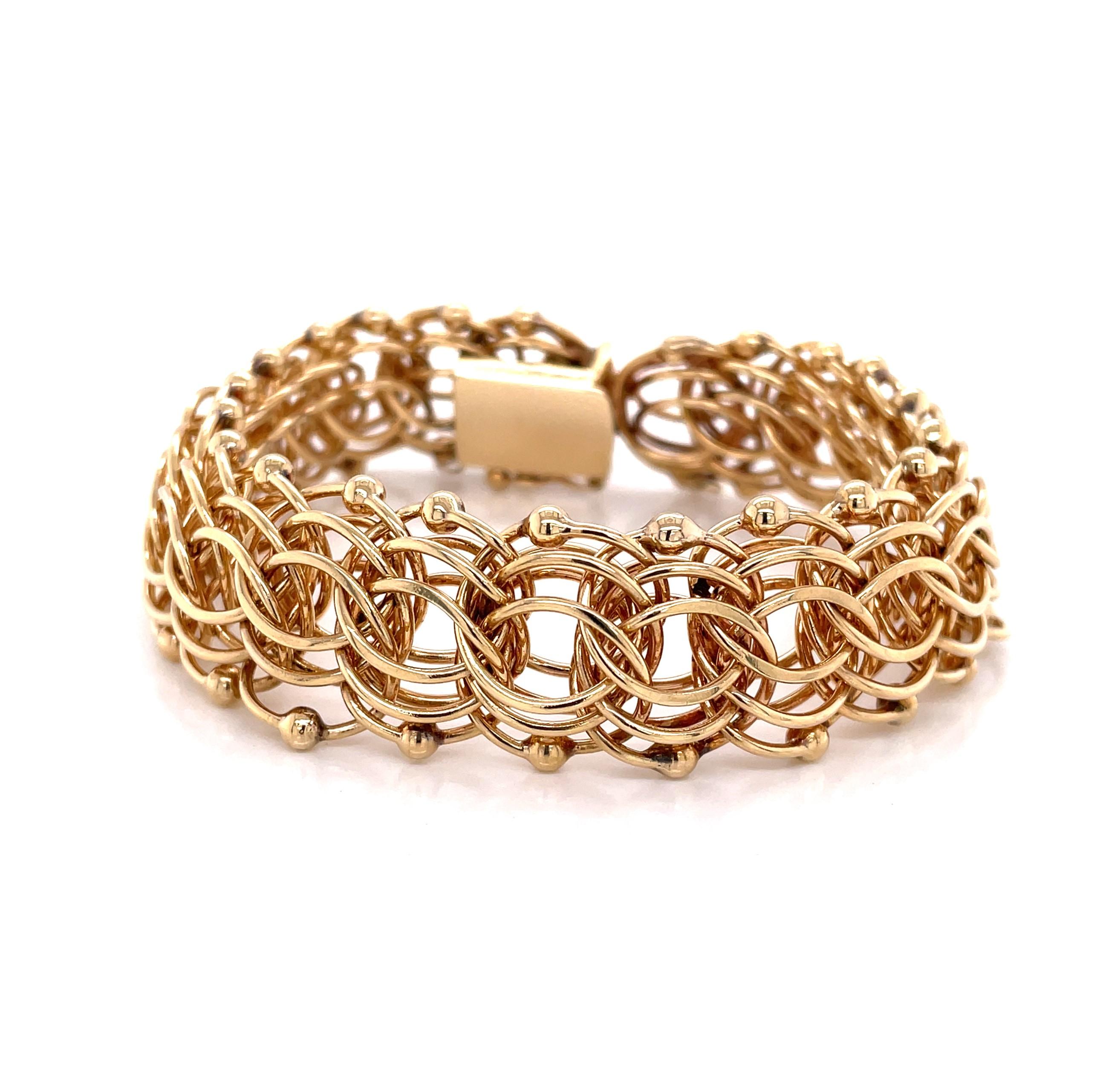 A sensational timeless classic. Bold, in 14 Karat yellow gold this substantial circa 1950's charm link bracelet makes a statement with twenty two interwoven gold 3/4 inch tri-links accented with a
gold bead edge detail. The bracelet's length is 8