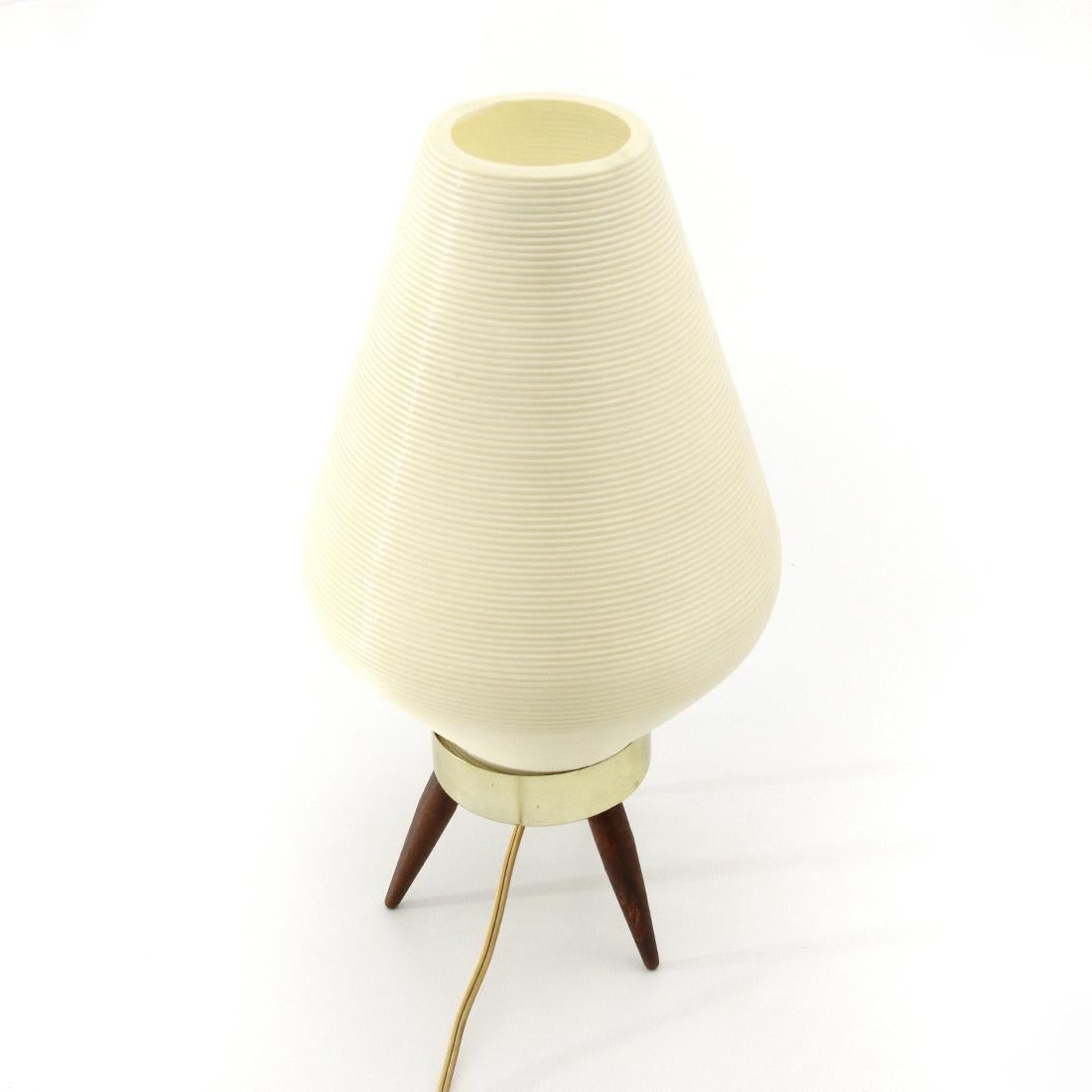American-made table lamp produced in the 1960s.
Brass-plated aluminum base with wooden legs.
Plastic diffuser.
Structure in good condition, small burn on the diffuser, some marks on one leg.

Dimensions: Diameter 18 cm, height 36 cm.