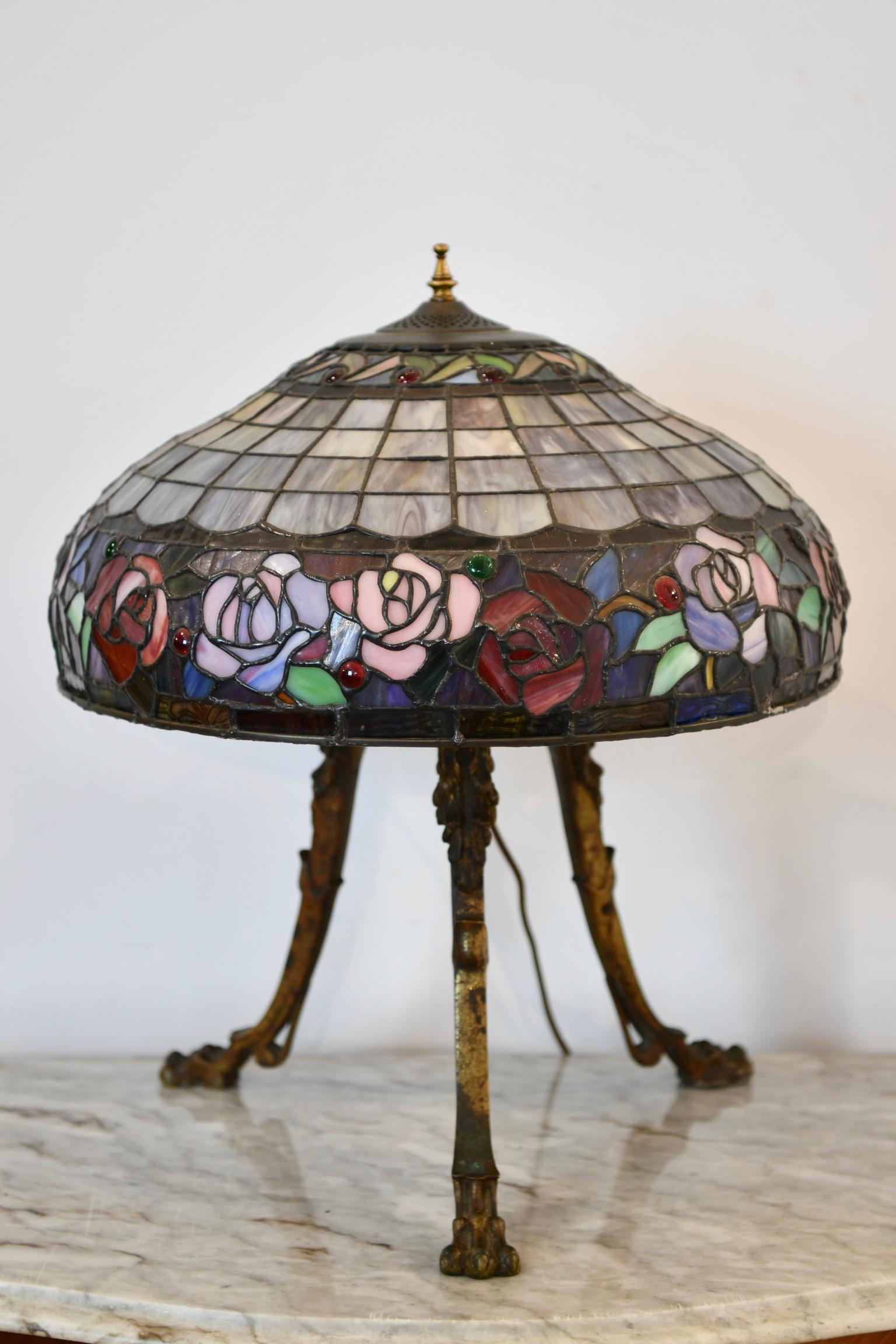 Stained glass shade table lamp with bronze tripod form base with claw feet. Dimensions: 20