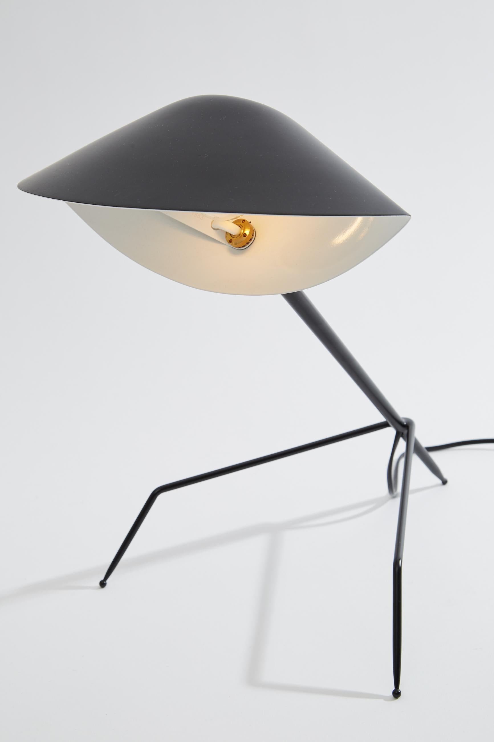 Tripod desk lamp originally designed by Serge Mouille in 1954. This desk lamp is a licensed re-edition from the “Black Shapes” series currently manufactured by Editions Serge Mouille in France. The steel base has three legs and an aluminium
