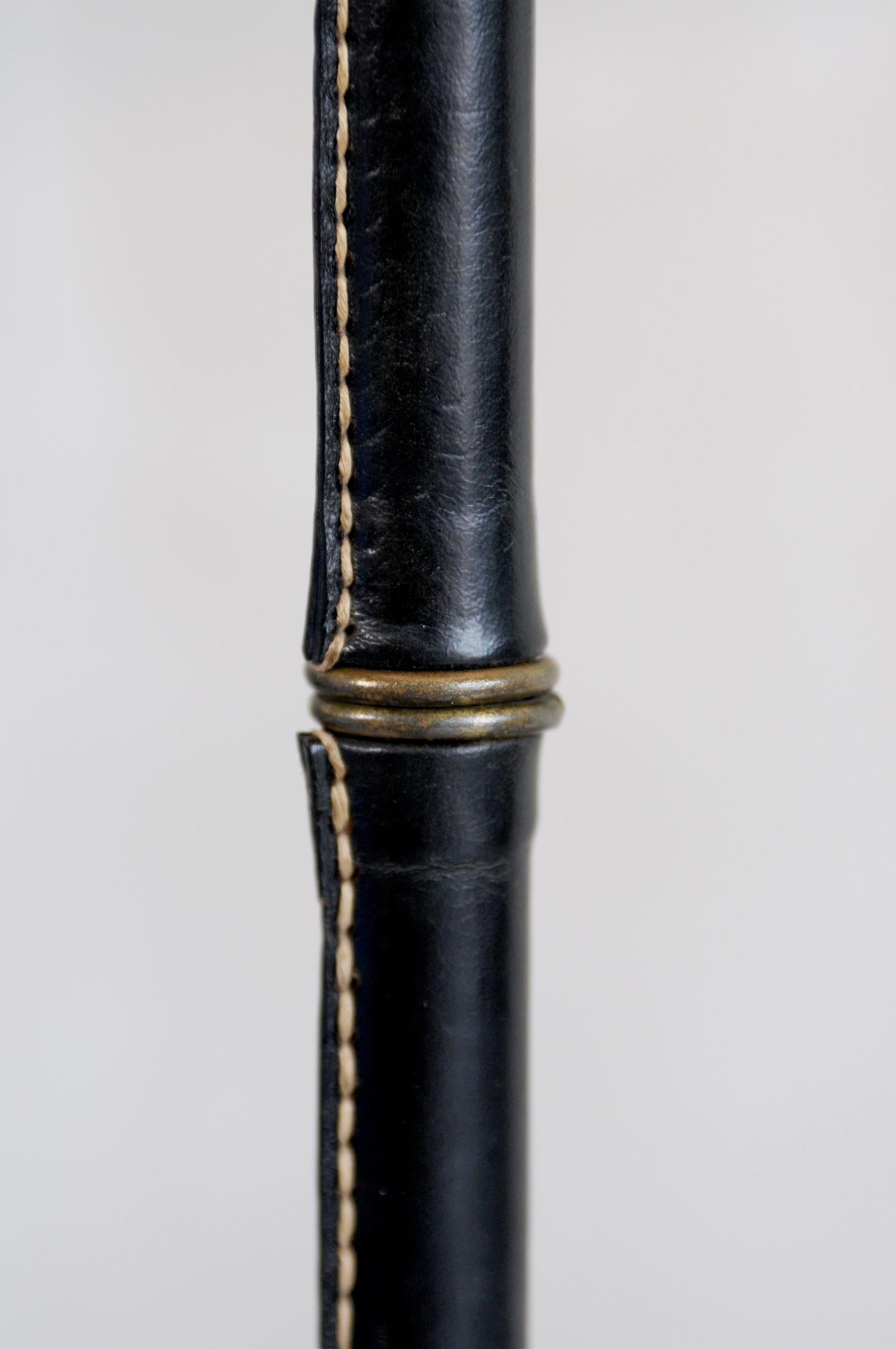Tripod floor lamp covered in black leather and ringed with brass rings by Jacques Adnet, France 1950.
Very good original condition.
At your request, a competitive freight quote will be provided.