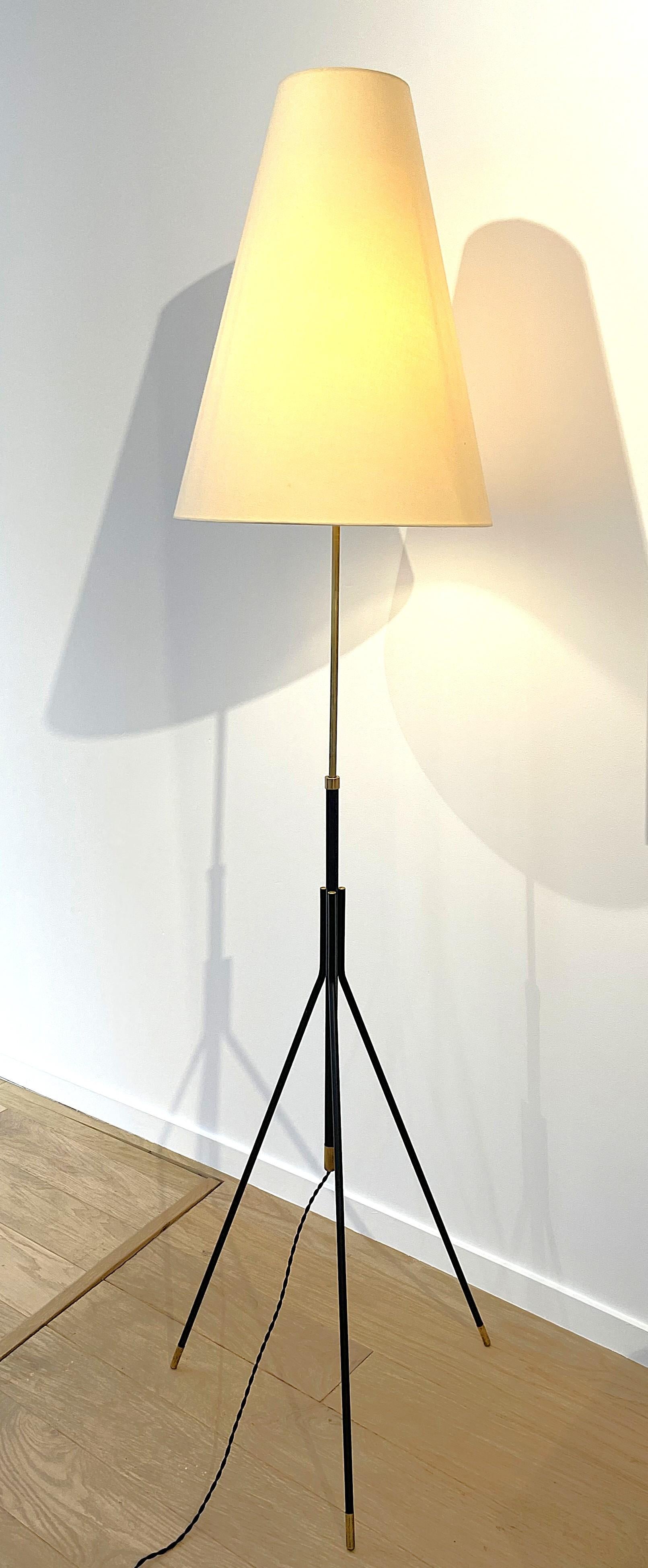 Tripod floor lamp attributed to Svend Aage Holm Sørensen. Antique lampshade in very good condition held by an original brass bracket, original bakelite switch. An elegant design with a beautiful black lacquered metal and brass structure that gives