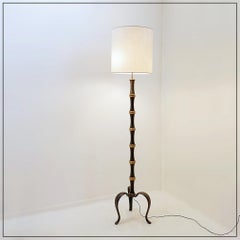 Tripod floor lamp in wrought iron and brass with a bamboo-style stem