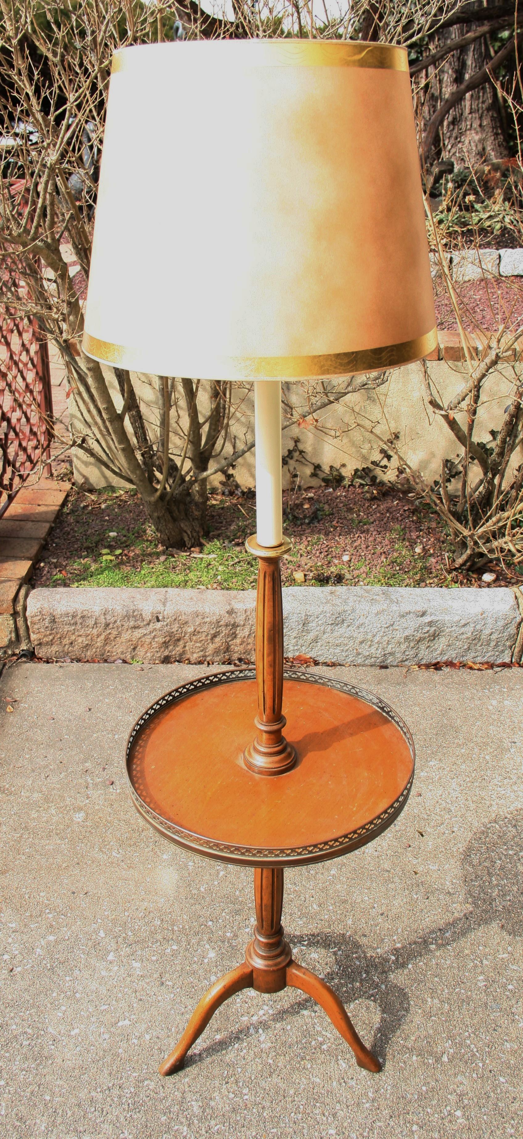 1597 tripod wood floor lamp with integrated table with brass gallery.
Measures: Height to top of socket 53