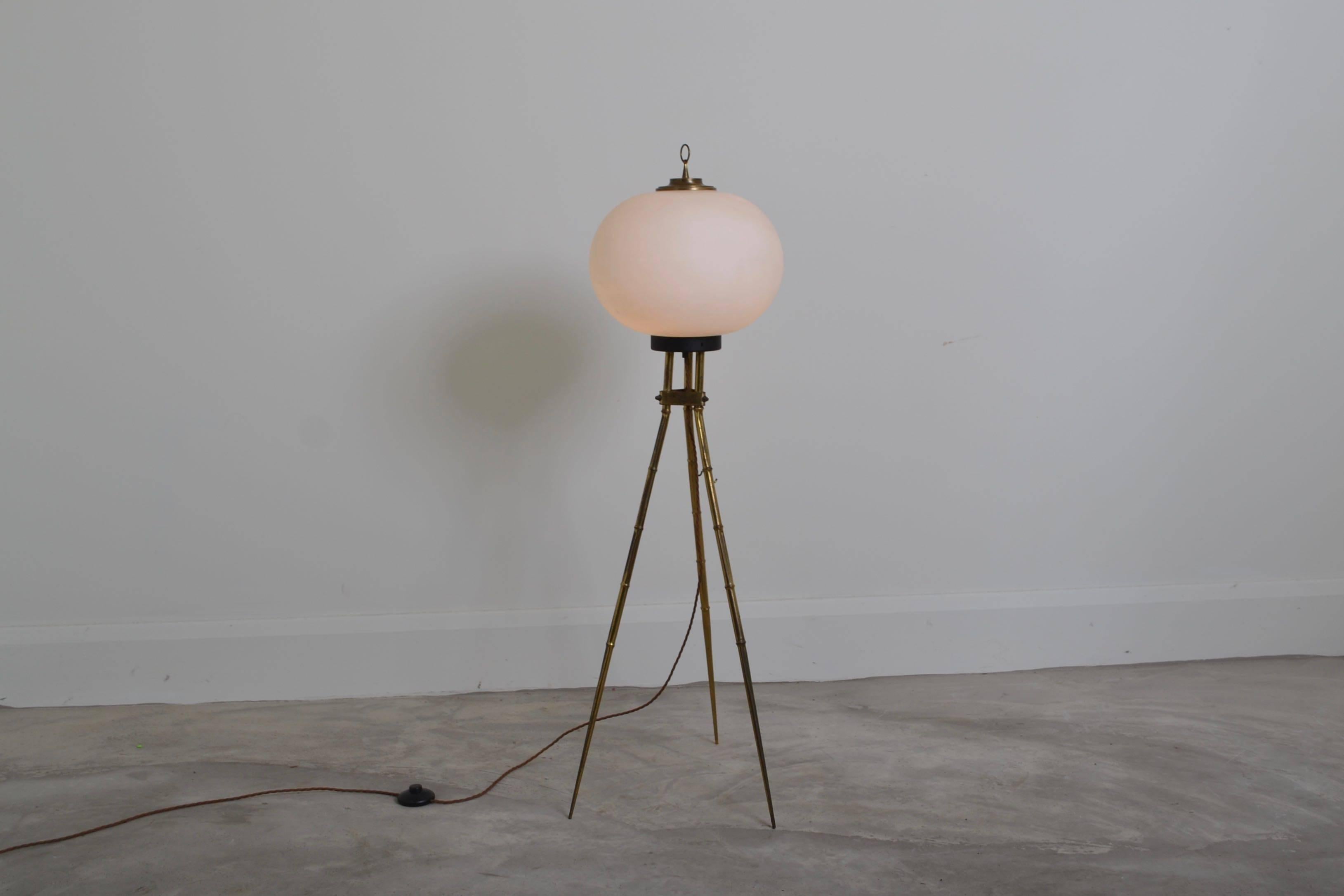 Unusual tripod floor lamp with oplaine glass shade.
The lacquered brass legs have a faux bamboo design.
Useful lamp to place by a sofa or chair.