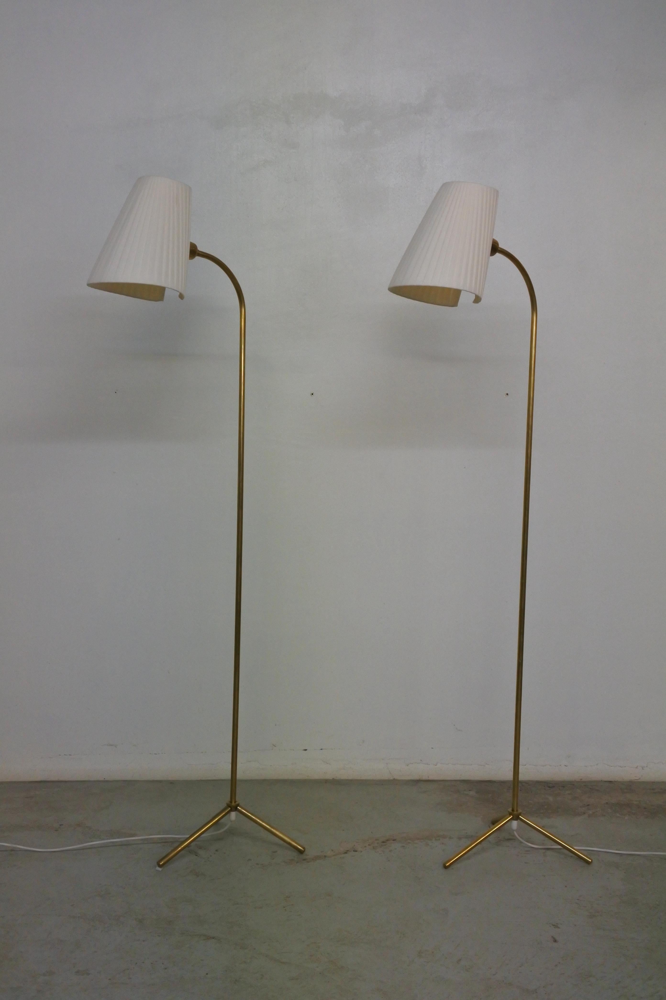 2 tripod floor lamps by Lisa Johansson Pape.
Manufactured by Orno in the 1950s.
Solid brass stems and feet, silk shades.
The shades can be orientated in all directions.

Even though the 2 floor lamps share the same provenance, they are slightly