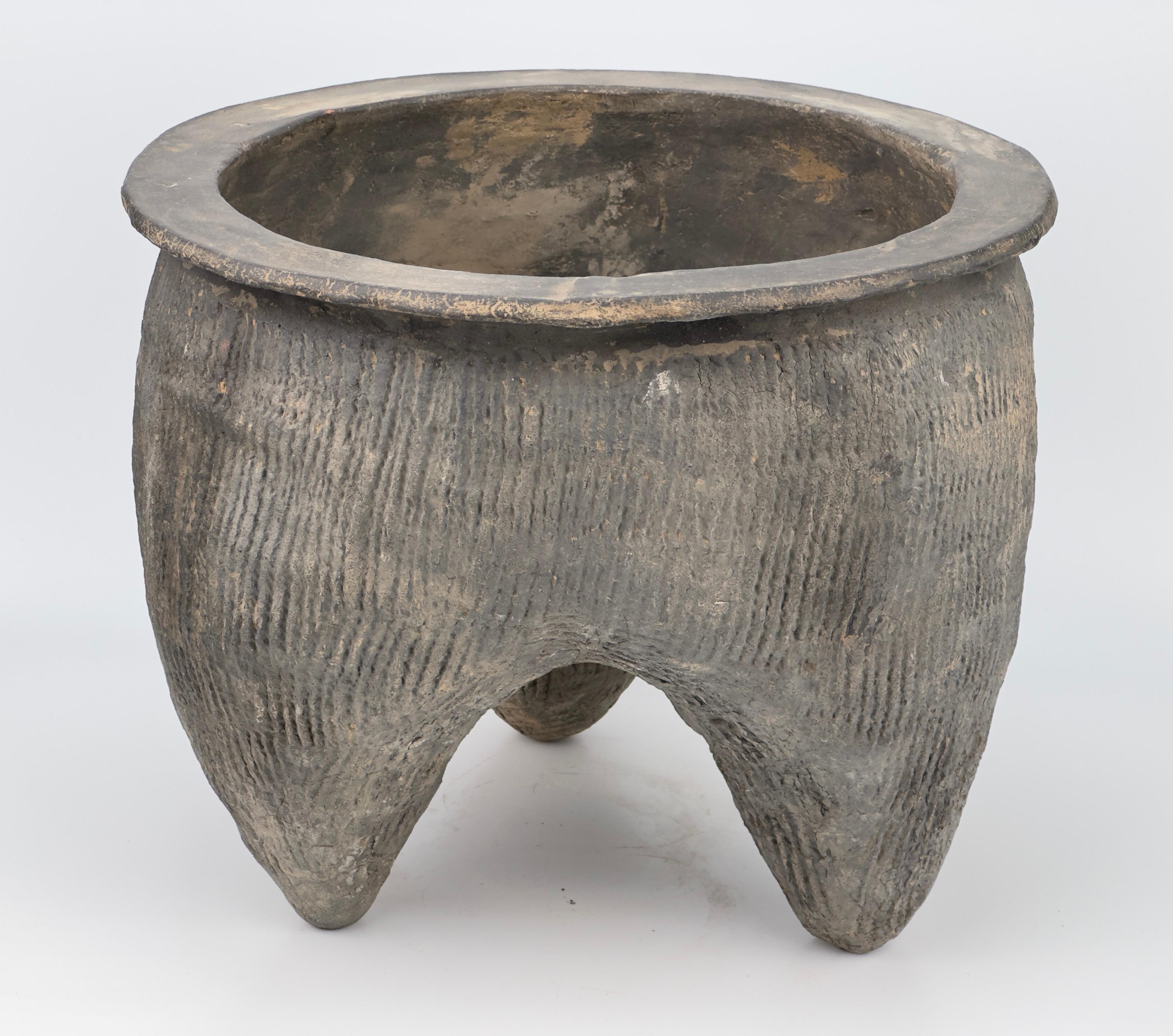 The tri-lobed shape and combed ridges of this cooking pot increased heating efficiency by maximizing the vessel’s surface area. The shape of a bronze vessel li, with the body rising out of three hollow pointed legs to a wide moiuth with splayed-out