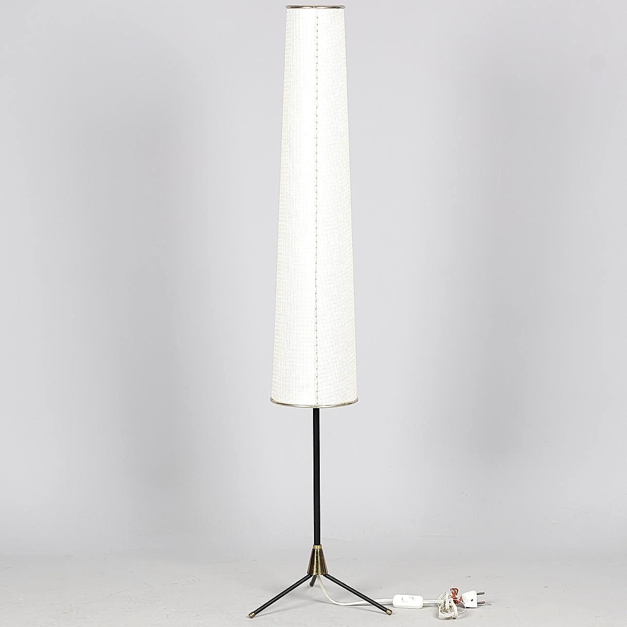 Tripod floor lamp attributed to Svend Aage Holm Sørensen, with an original rhodoid lampshade. This lamp, featuring a beautiful structure in black lacquered metal and brass, casts a soft and pleasant light and can be used either as a floor lamp or