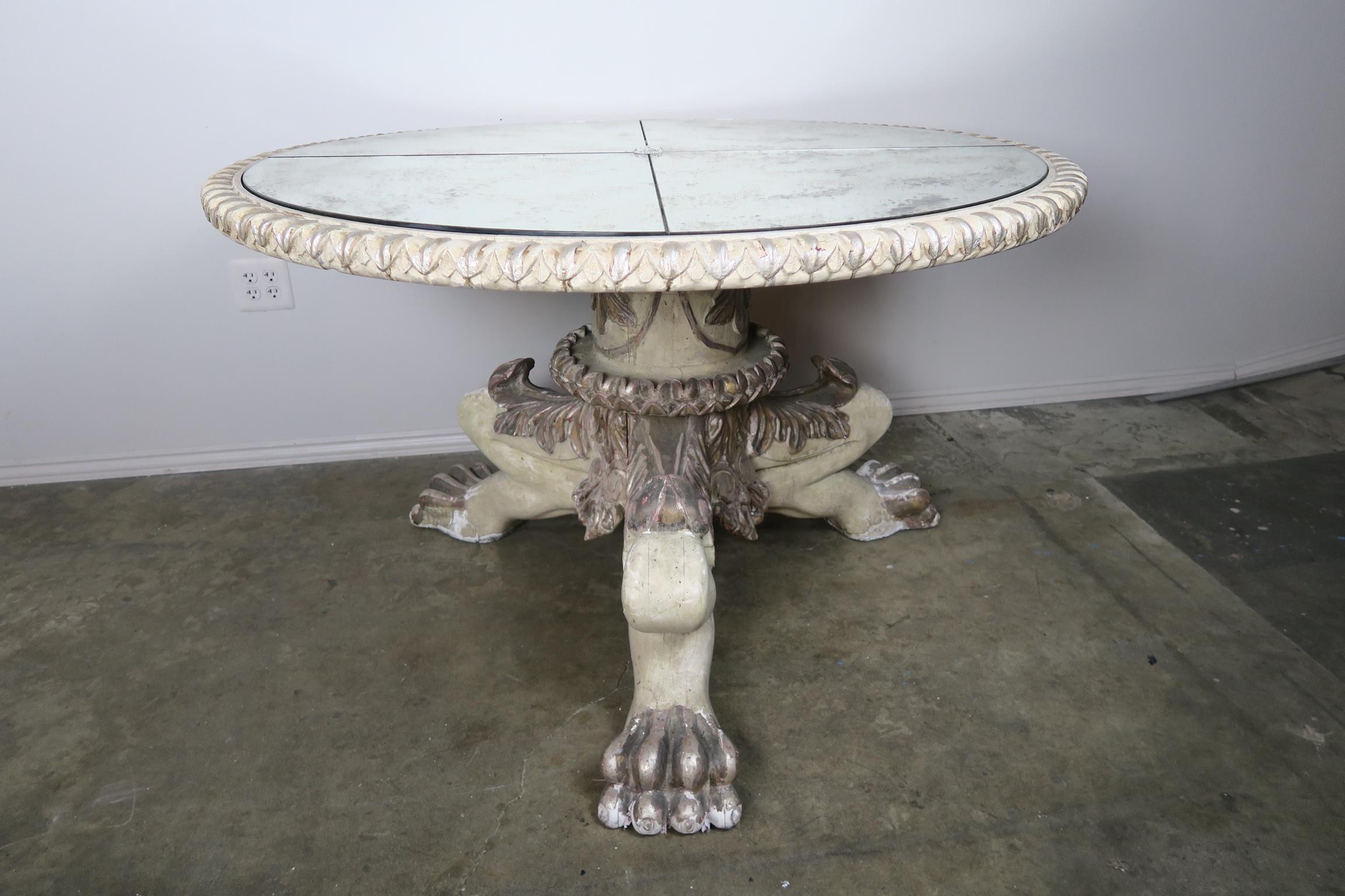handcrafted by Melissa Levinson, this hand carved painted and silver gilt tripod lion paw table base supports a unique quartered mirrored top that has been aged to perfection and finished with a center crystal rosette. The finish has also been aged