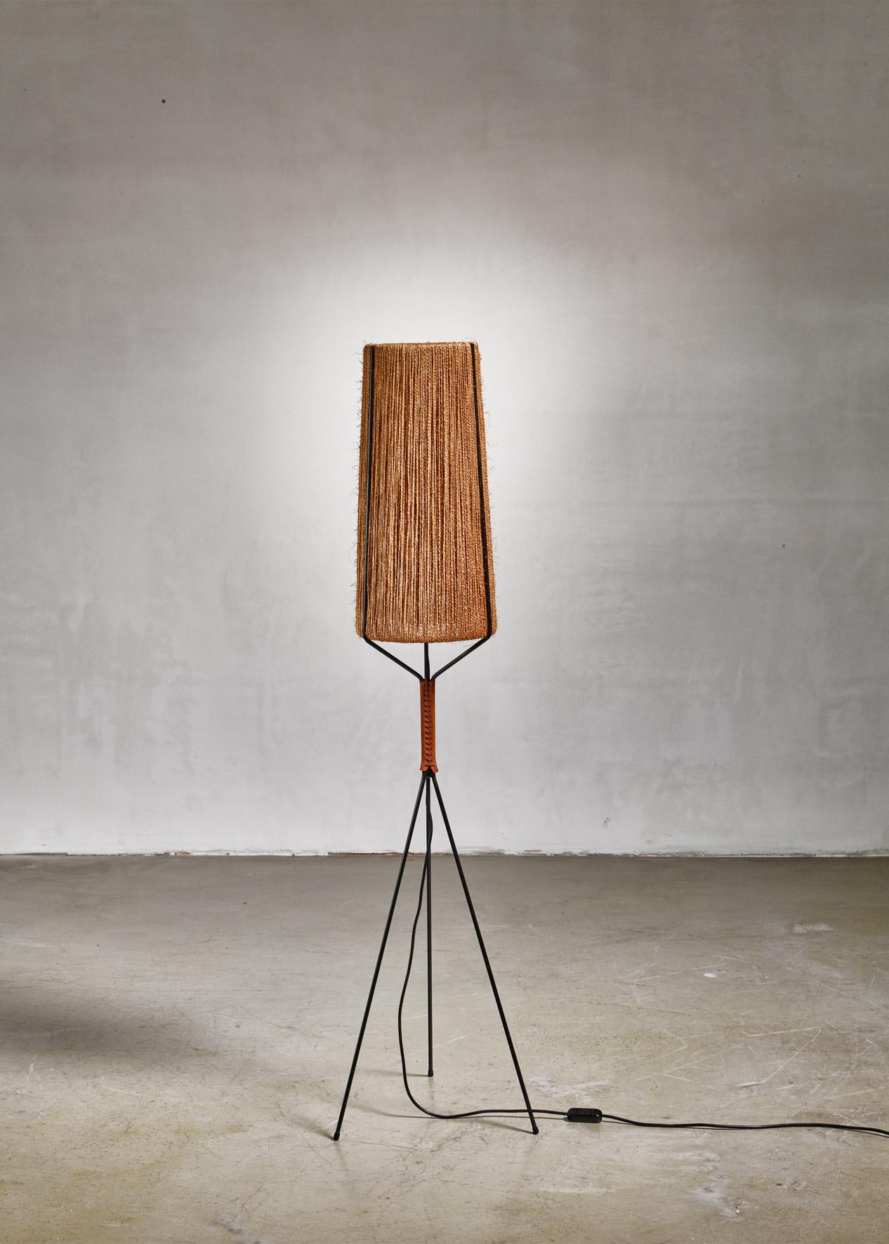 A Danish floor lamp in the manner of Ib Fabiansen or Svend Aage Holm-Sørensen. The lamp has a black lacquered steel tripod base with a leather part and a woven rope cylindrical shade.