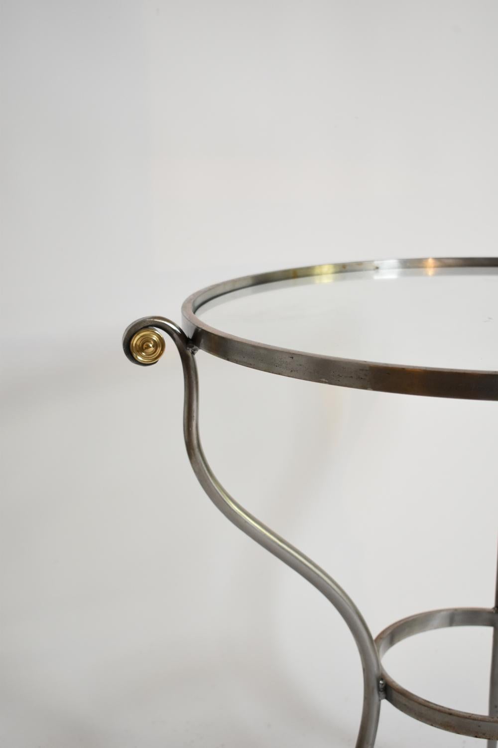 Runder Tisch mit dreibeinigem Sockel, Beistelltisch mit gewölbtem Metallsockel, der zwei runde Glasplatten trägt. Frankreich, 1970er Jahre.