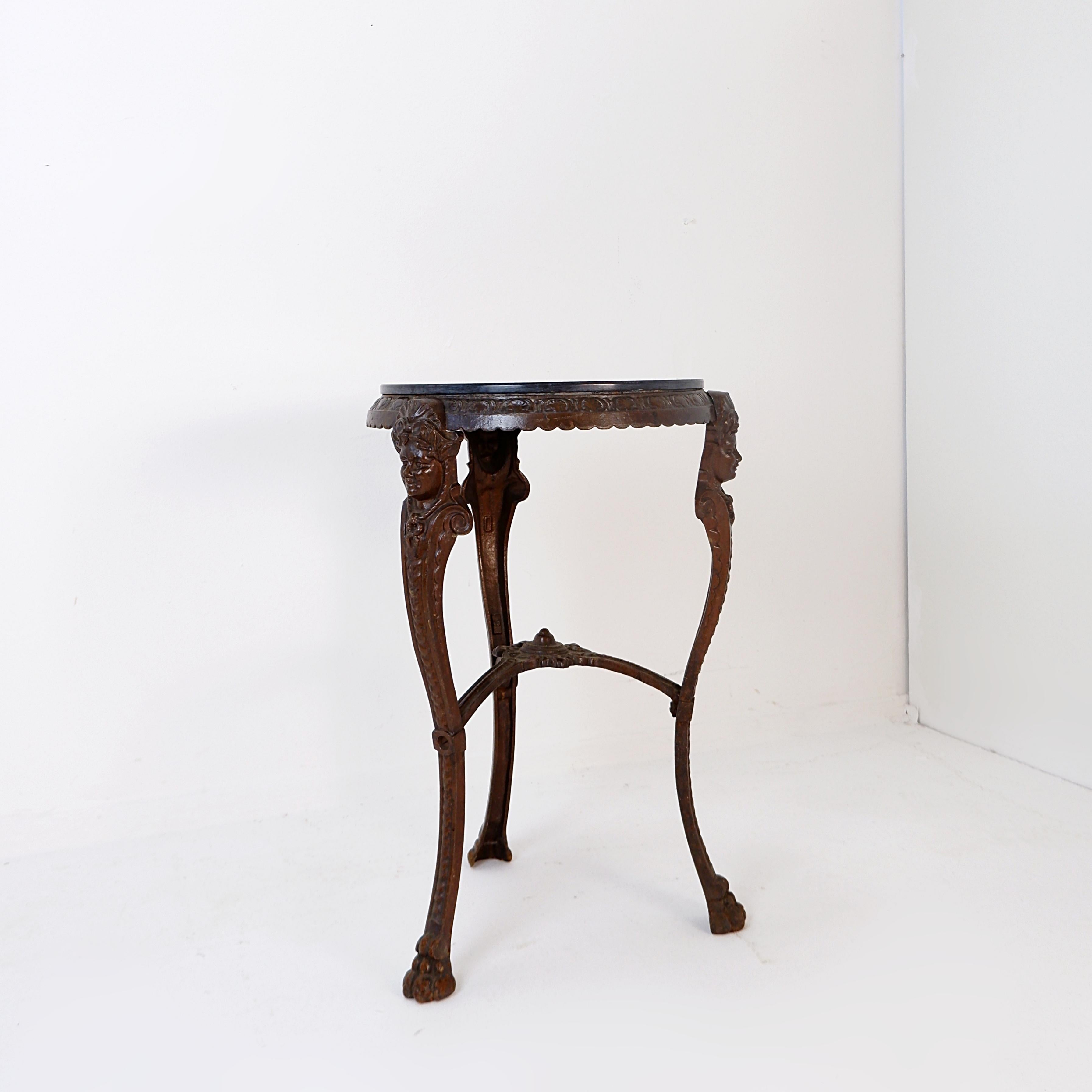 Tripod pedestal table
Antique - Decoration - 19th
Victorian cast iron consol base with ornate design, featuring stylized faces and delicate detailing. 
Marble top. 
Measures : Top Ø 36,5cm Tot : 40cm H: 62cm 
Materials : Iron - Marble 
