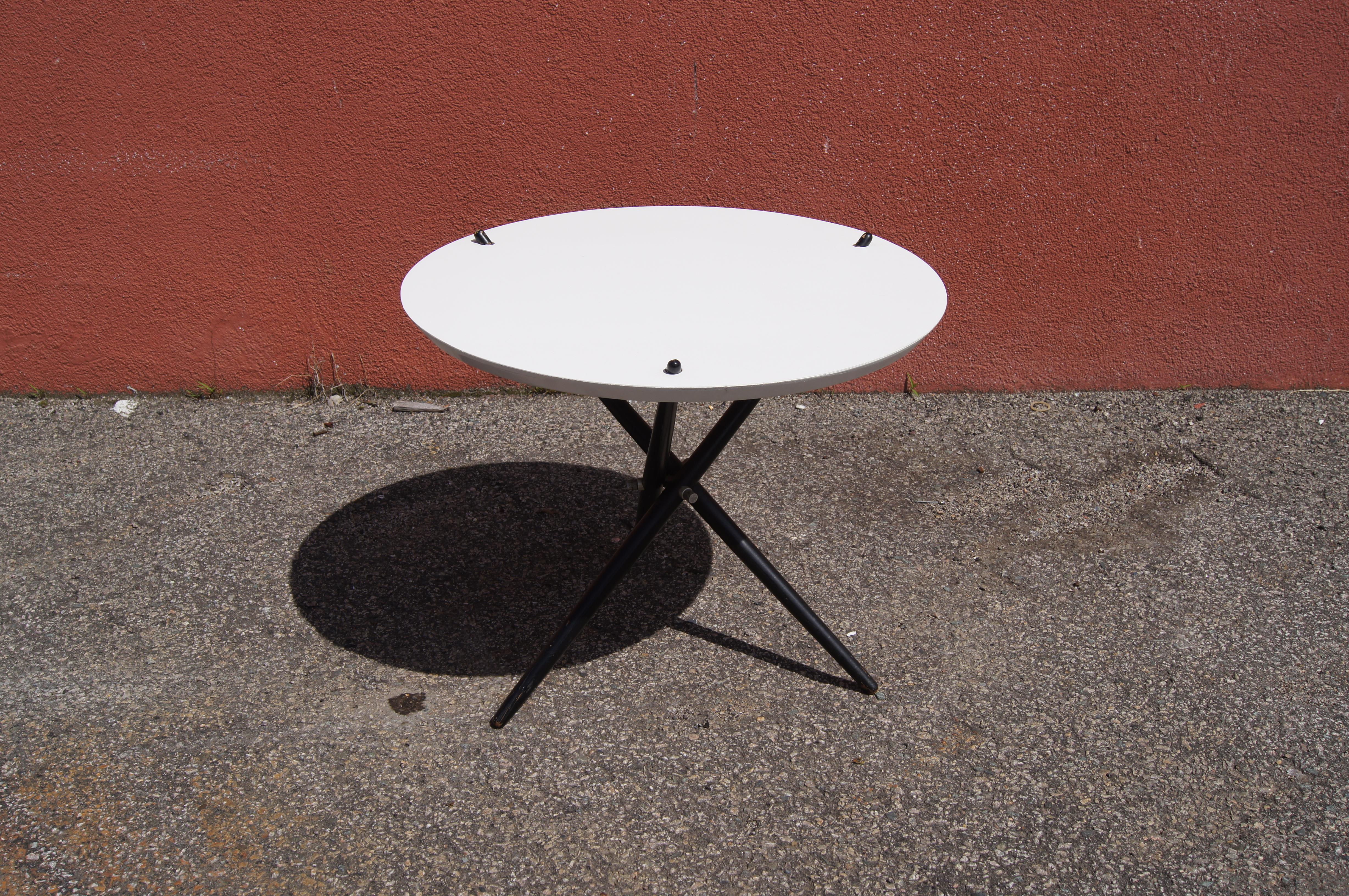 Der 1947 vom Schweizer Designer Hans Bellmann entworfene und ein Jahr später als Modell 103 für Knoll produzierte kleine Tisch ist ein modernes, vielseitiges Möbelstück für viele Bereiche. Eine runde, weiße Laminatplatte wird von einem Dreibein mit