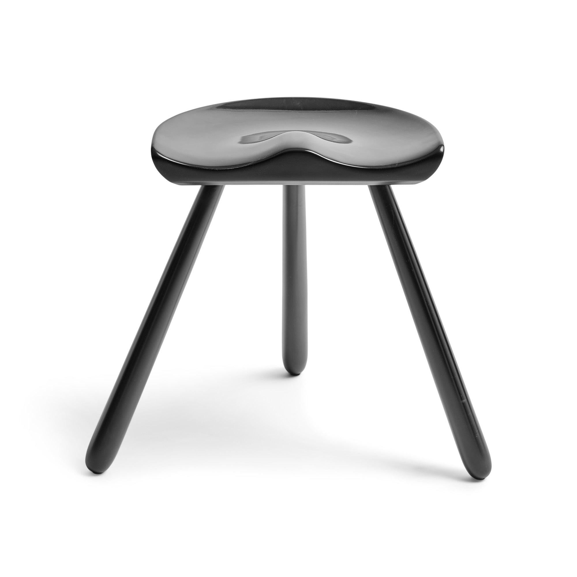 This Danish tripod stool by Arne Hovmand-Olsen features a unique halved seat inspired by traditional milking stools. Despite its robust appearance, the stool offers a comfortable seating experience thanks to the ergonomic wooden 'seat saddle.' Its