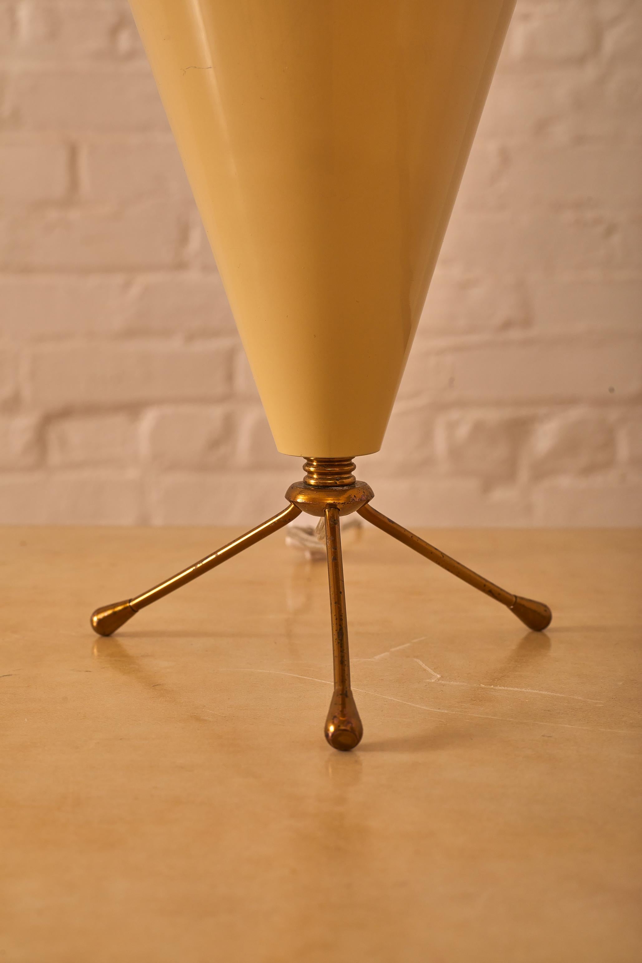 Tripod table lamp in with brass legs. 

