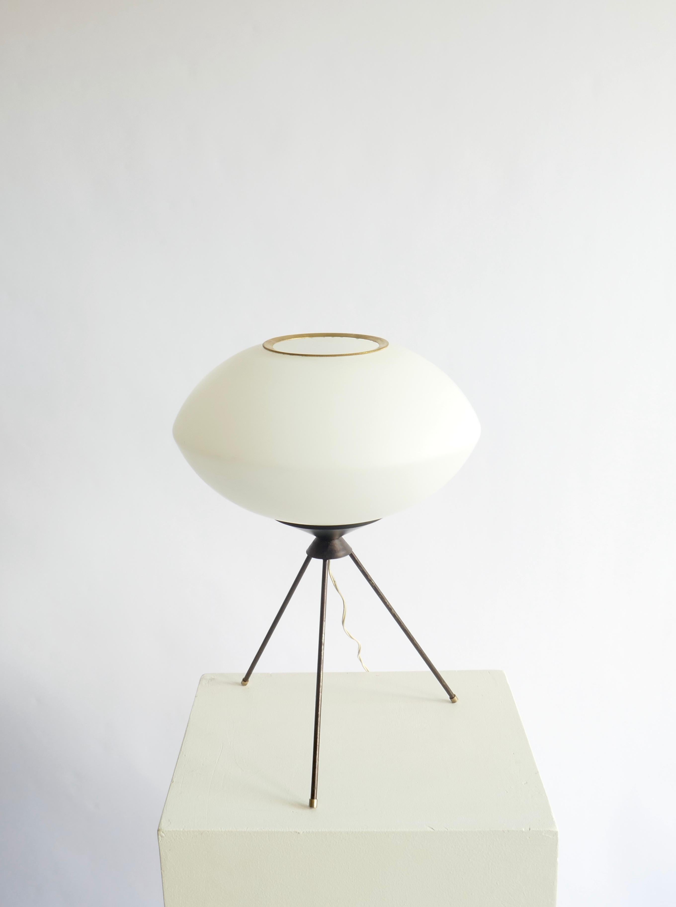 A versatile table lamp. A wrought iron tripod base and an opaline glass globe.
Italy, 1950s.

