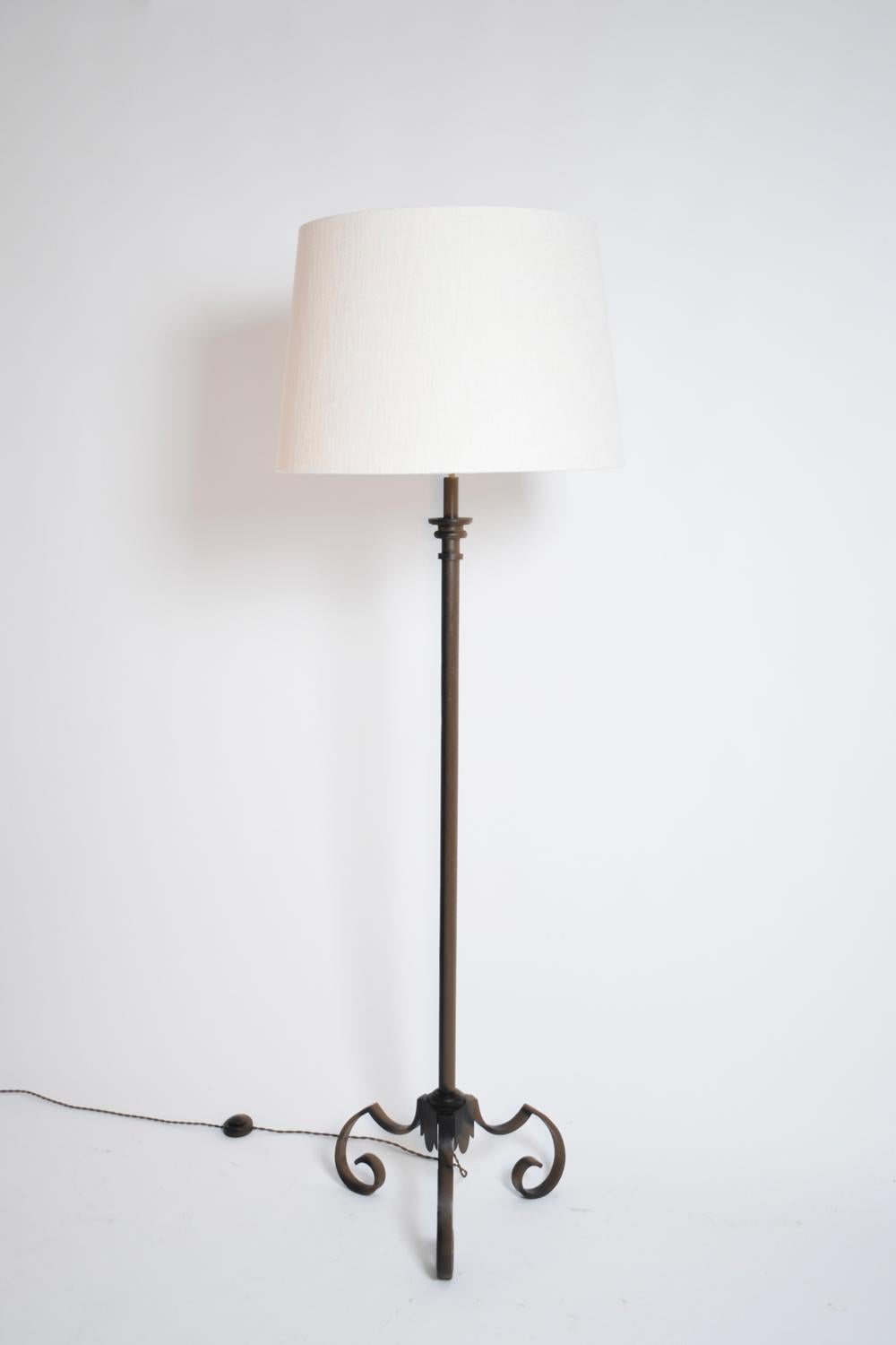 Tripod floor lamp in black lacquered tubular wrought iron, straight shaft. France, 1950s.