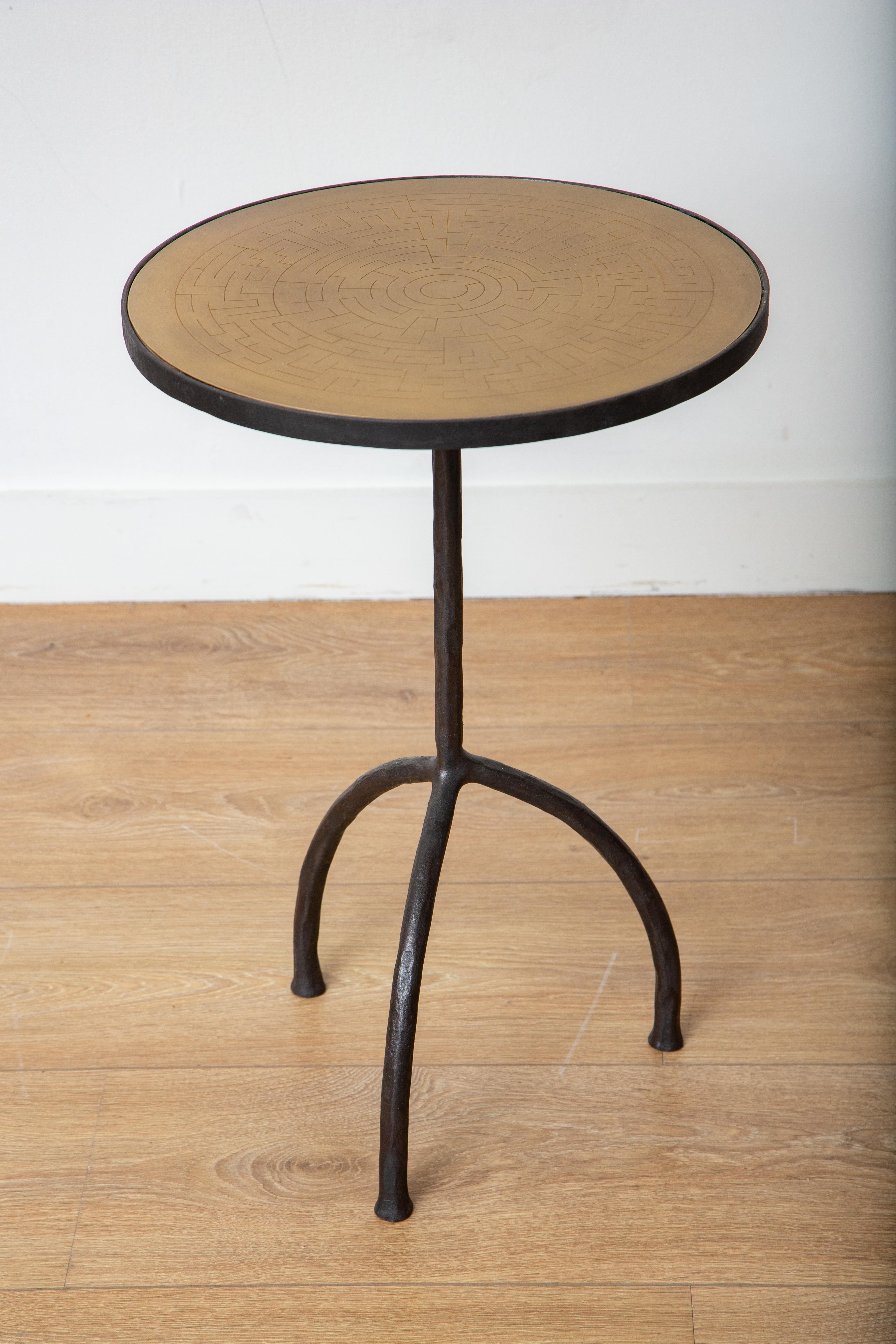 tavolino tripode in ferro battuto con piano in ottone acidato.
Questo splendido tavolino a treppiede in ferro battuto è un'aggiunta accattivante all'arredamento di qualsiasi casa. Il suo piano rotondo in ottone con chiave greca incisa e la sua