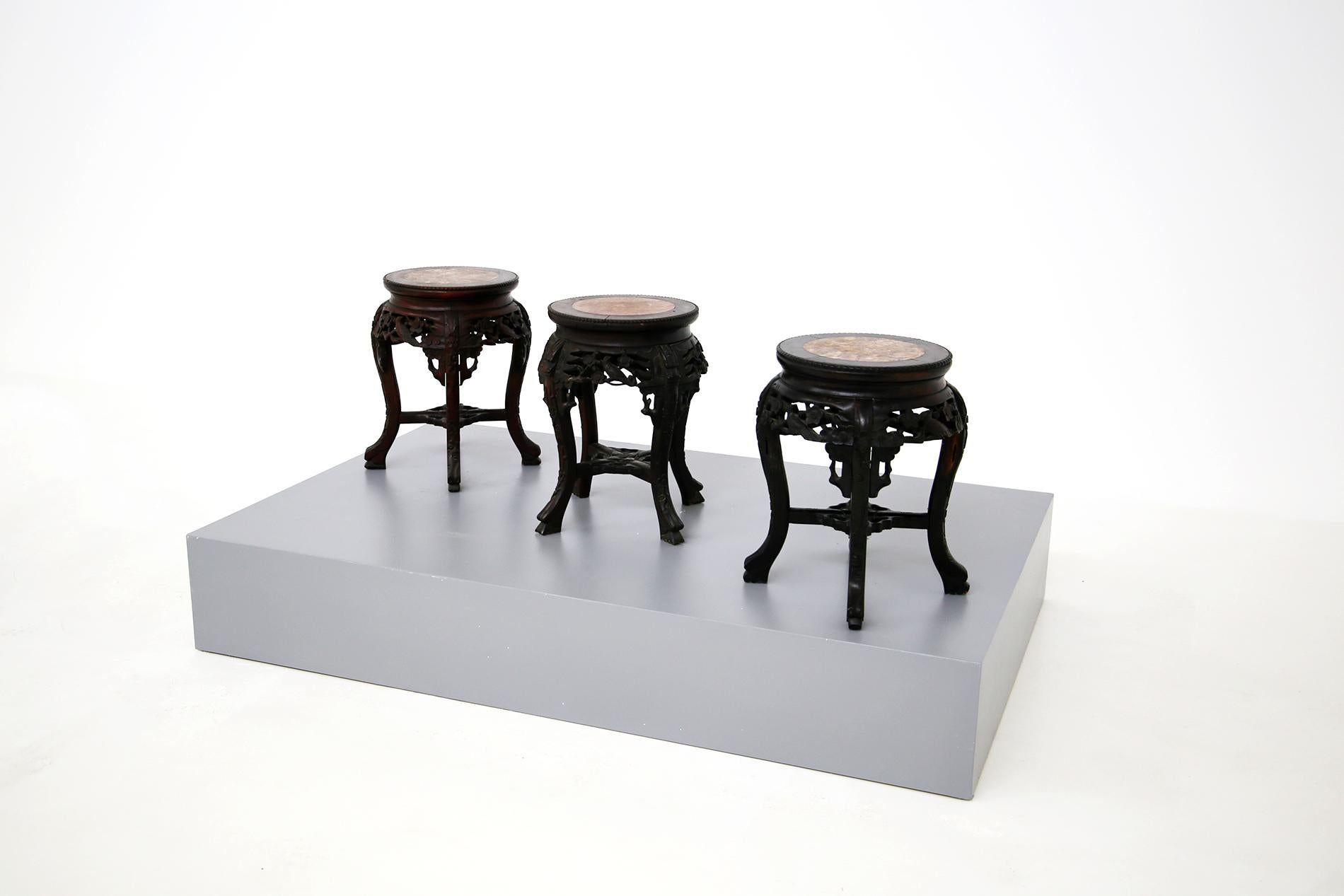 Trittico di portavasi cinesi in legno ebanizzato con piano in marmo, fine del 1800. Elegante trittico di portavasi di fine '800 e inizio '900 cinese. La struttura dei tavoli è in legno ebanizzato abilmente intagliato con fregi e disegni di fiori e