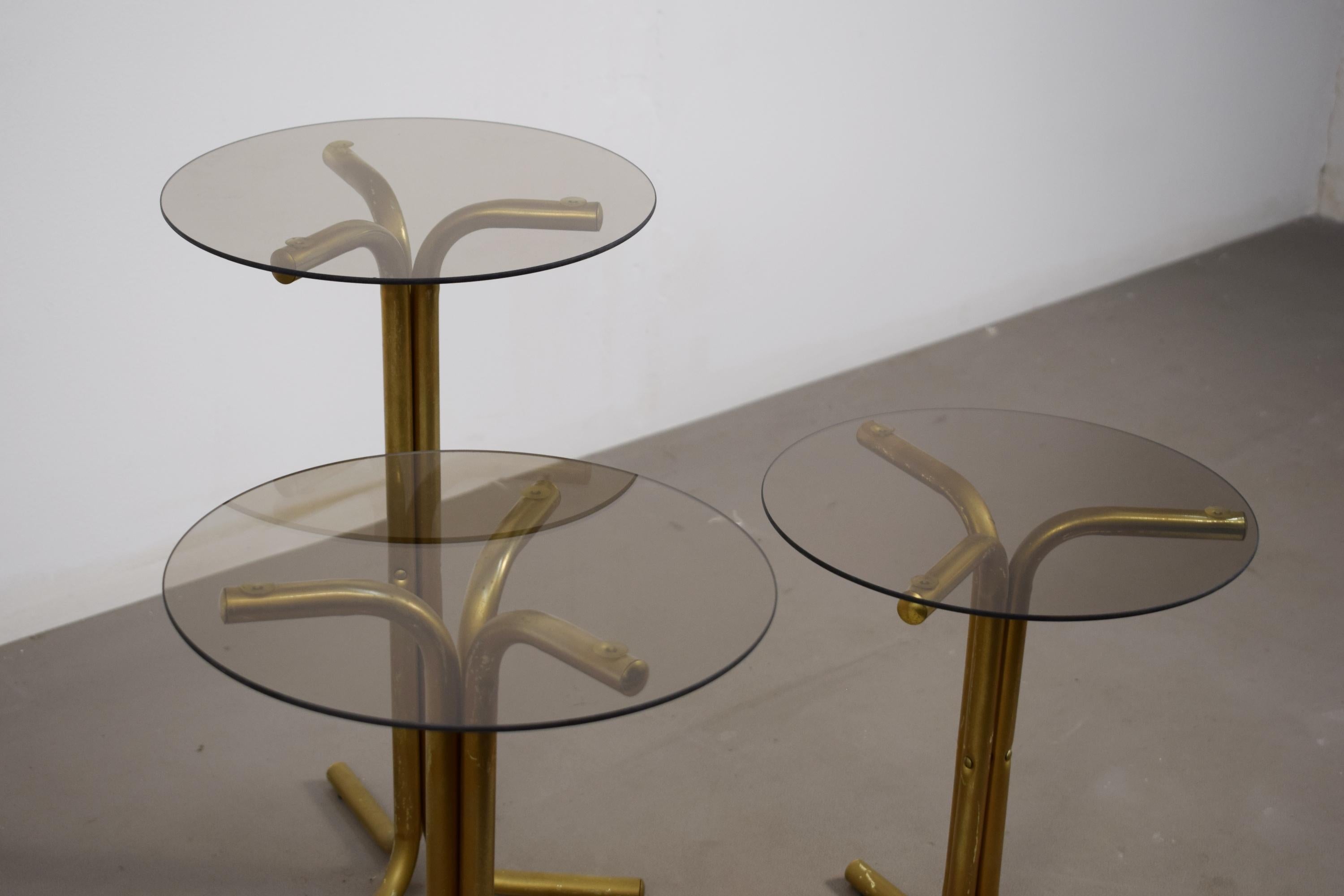 Tris di guéridon o tavolini con struttura in ottone e vetri circolari fumè, produzione italiana degli anni '70 circa.
Parfaits pour être placés à proximité d'un divan ou d'une chaise, prêts à être utilisés.
Buone condizioni, presentano normali segni