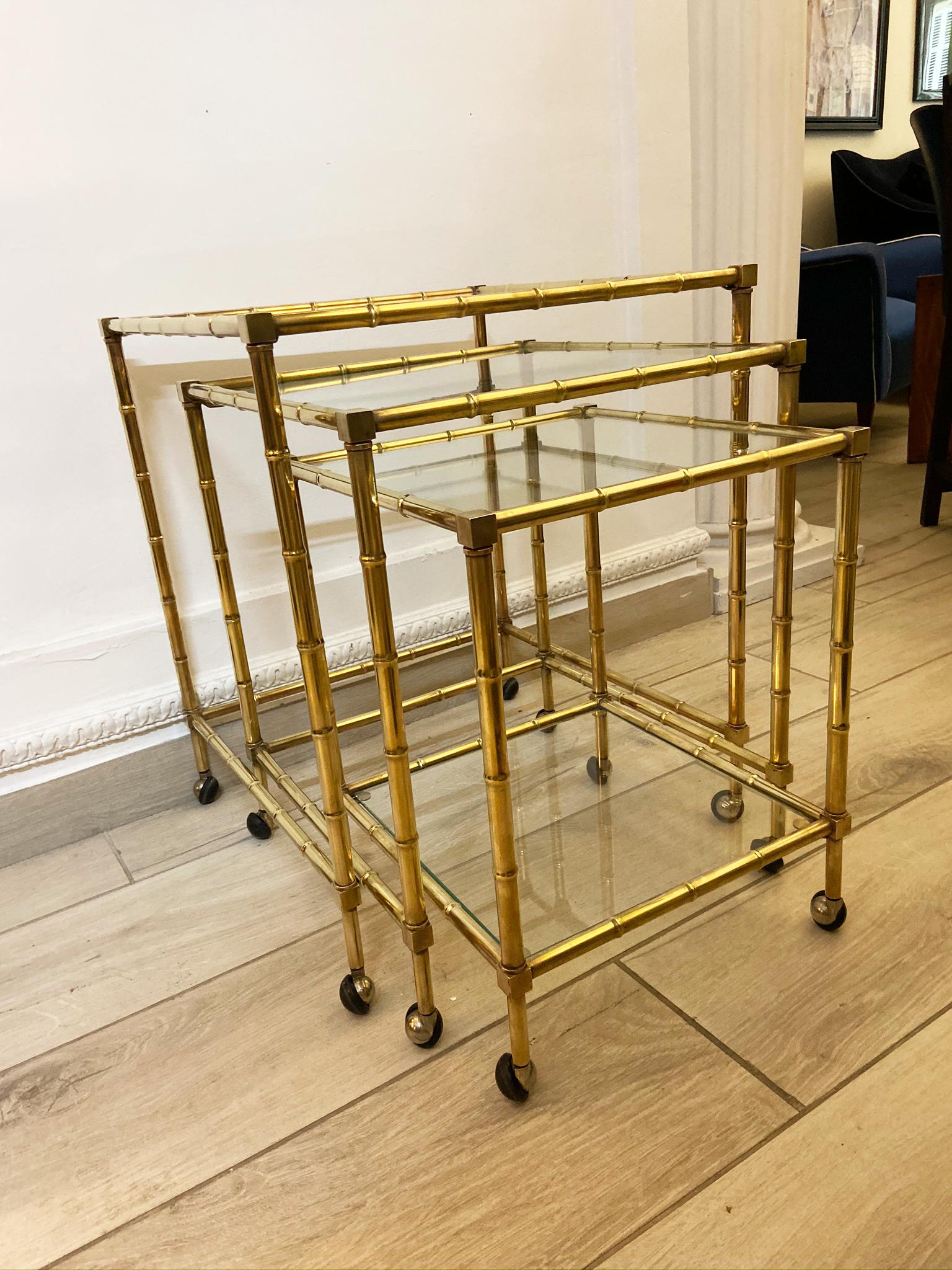 Wonderful tris of faux bamboo nesting trolleys in gilded brass and clear glass tops, in the style of the Maison Baguès.