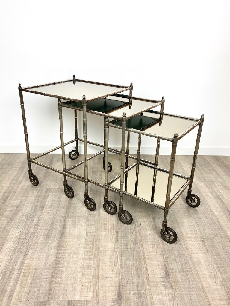 Tris of nesting side table bar cart in silvered brass and smoked mirror by Maison Baguès Paris, circa 1960.

Maison Baguès is renowned for fine brass objects and lights since its establishment in 1860. The idiosyncratic genius Armand-Albert Rateau