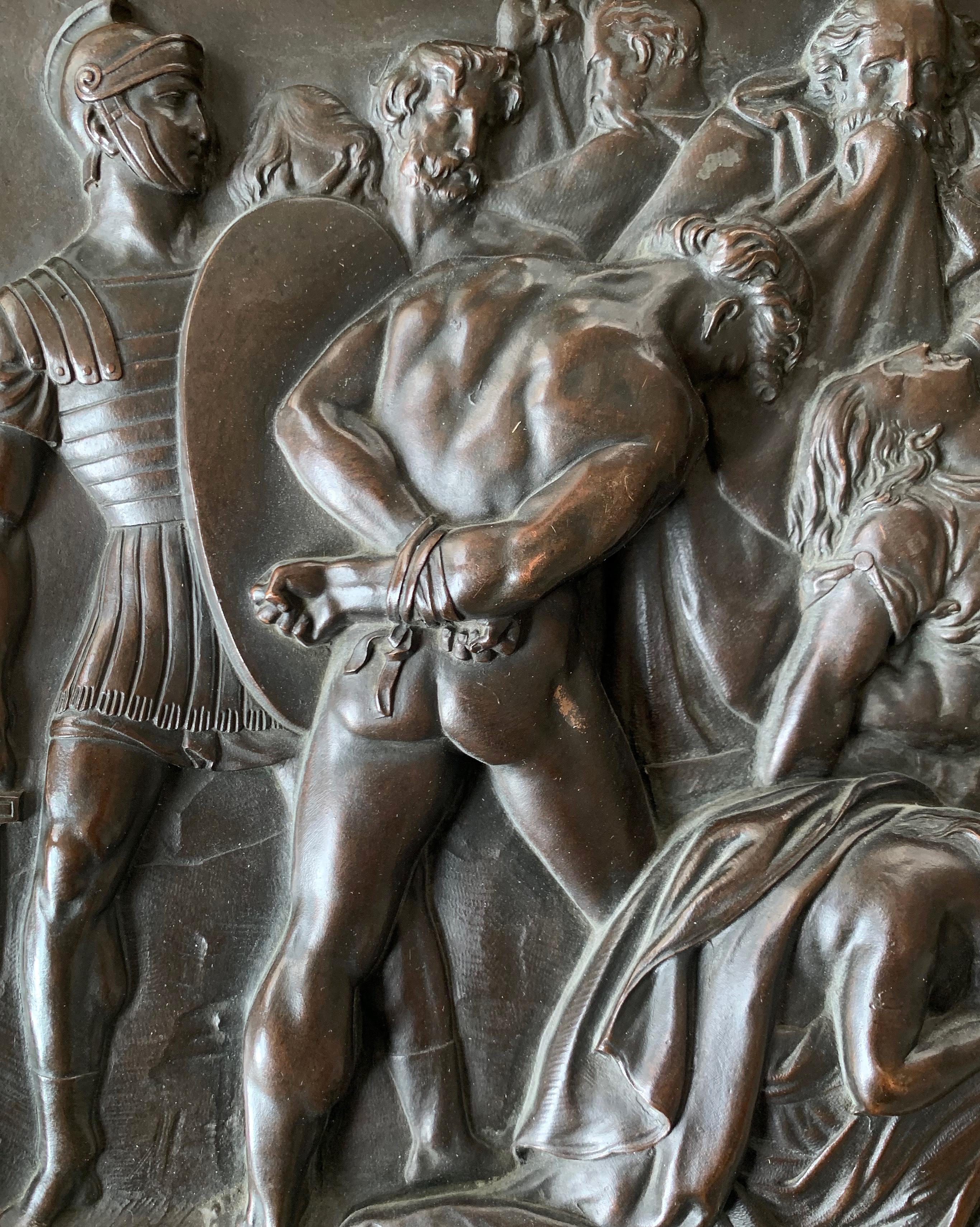 Beautifully detailed and masterfully cast and patinated, this bronze panel, probably from the late 19th or early 20th centuries, depicts a frieze of Roman soldiers at the end of battle, arrayed across the field with the forces they defeated either