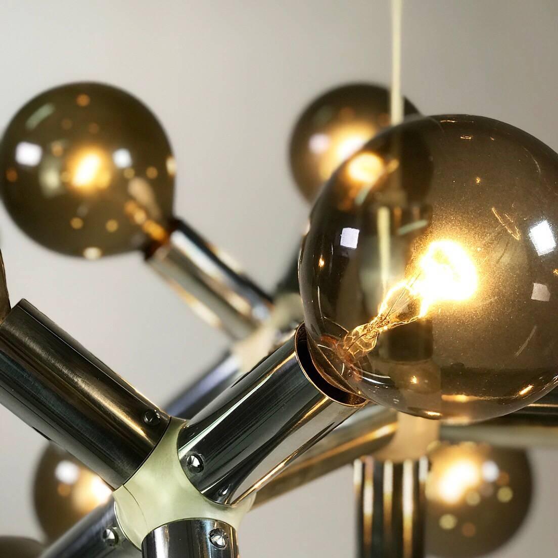 All original stunning piece of Swiss design from the 1960s. 

The atomic age molecule chandelier was designed by the renowned couple Trix and Robert Haussmann and produced by Swiss Lamp International. 

The beautiful chromed chandelier comes