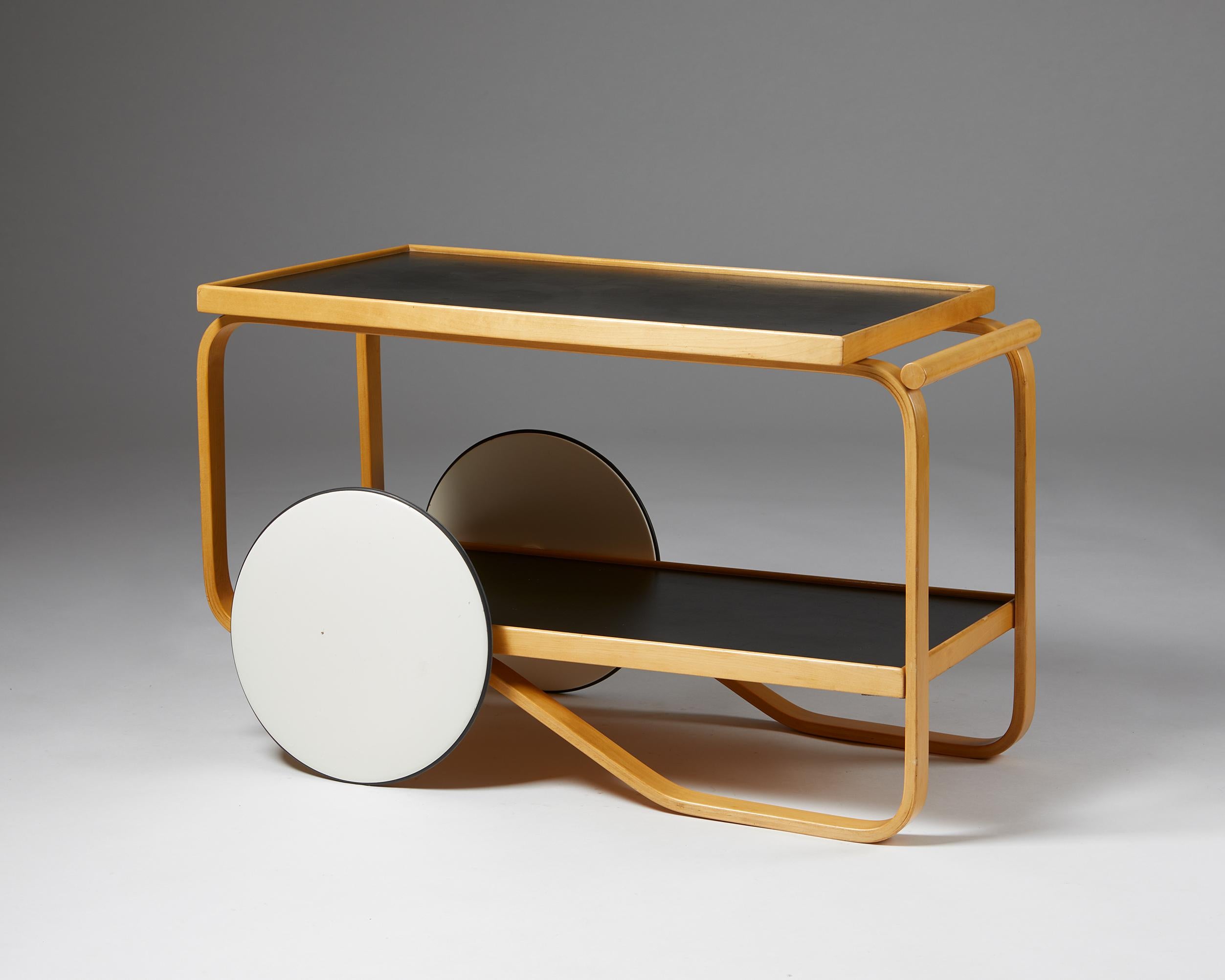 Trolley ‘model 901’ designed by Alvar Aalto for Artek,
Finland. 1950s.
Birch frame, black linoleum shelving, and white lacquered wooden wheels.

This rare trolley 