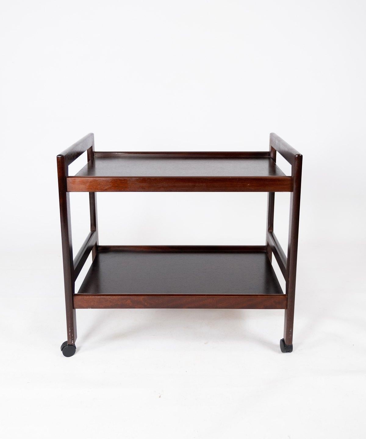 This Danish-designed trolley table from the 1960s combines sleek design with practical functionality. Crafted from rich mahogany, it exudes warmth and sophistication, adding a touch of elegance to any room.

Featuring clean lines and a minimalist