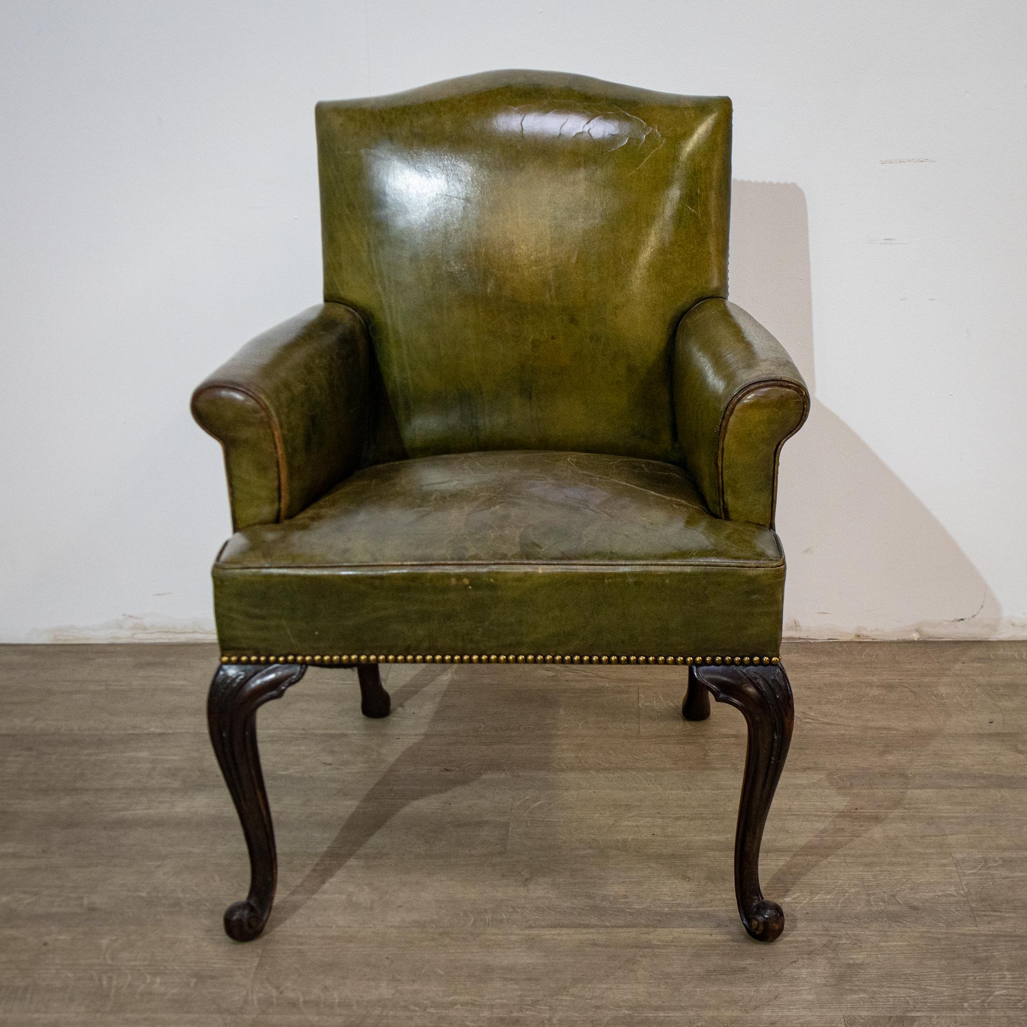 An attractive leather armchair suitable for a desk, this is in an olive green colour and has a mahogany frame with cabriole legs. The seat is sprung and there is some lovely leather piping around the fronts of the arms and the seat, with upholstery