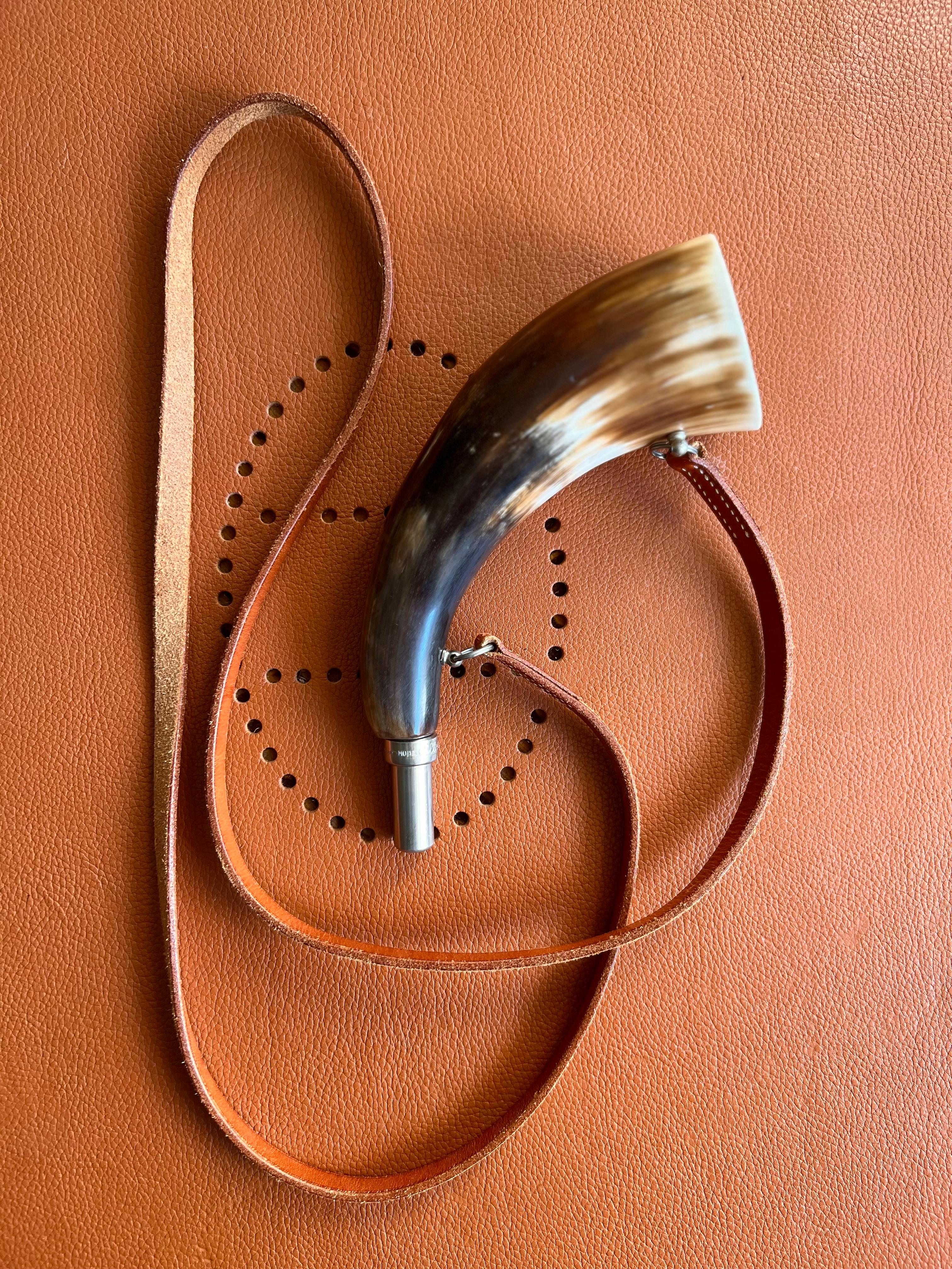 Hermès Vintage Selection by Corrado Luxury - Seltene Elless Marke Kuhhorn Jagdtrompete für Maison Hermès, auf verchromtem Metall montiert leichte Gebrauchsspuren entlang der natürlichen Kuhfell Schnur. Länge des Schultergurts 142 cm. Verkauft