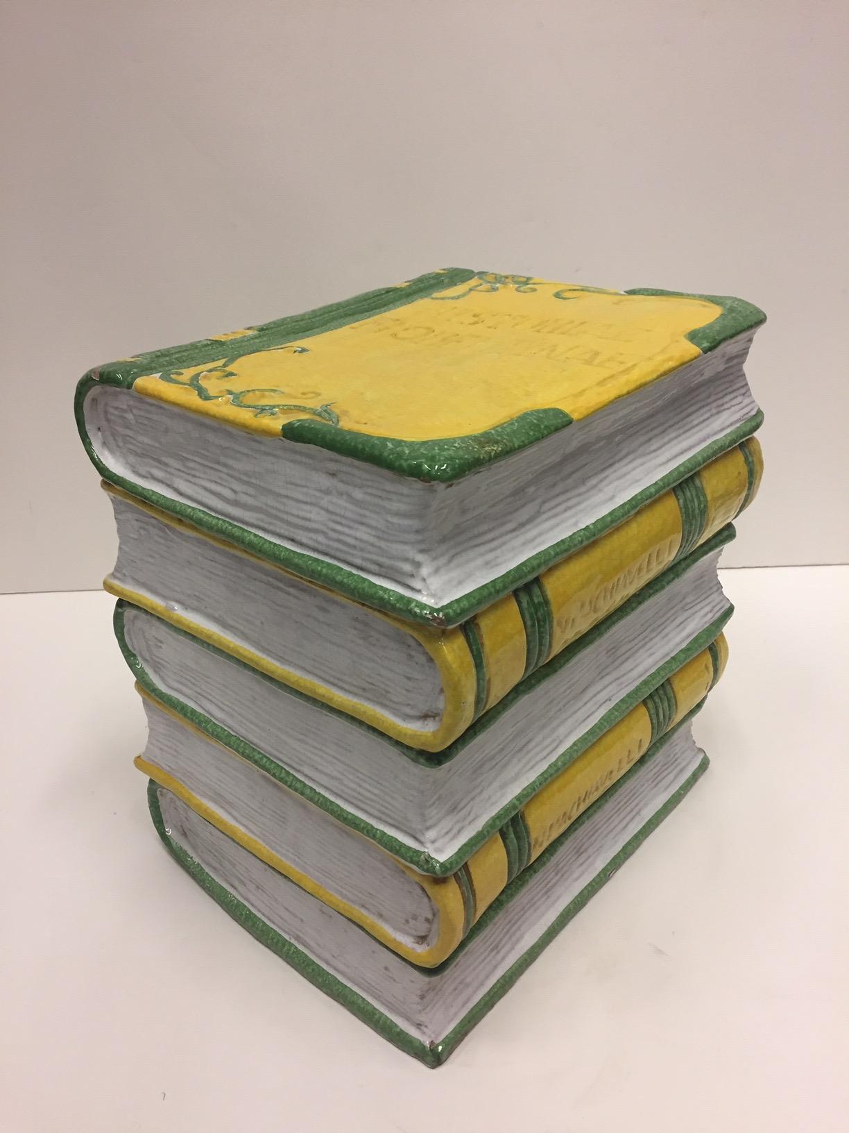 A beautiful and unusual glazed terracotta garden seat in the form of a stack of books. Colors are a snappy white, yellow and green and the embossed Italian writing on top is a wonderful element. Great as a stylish drinks table.